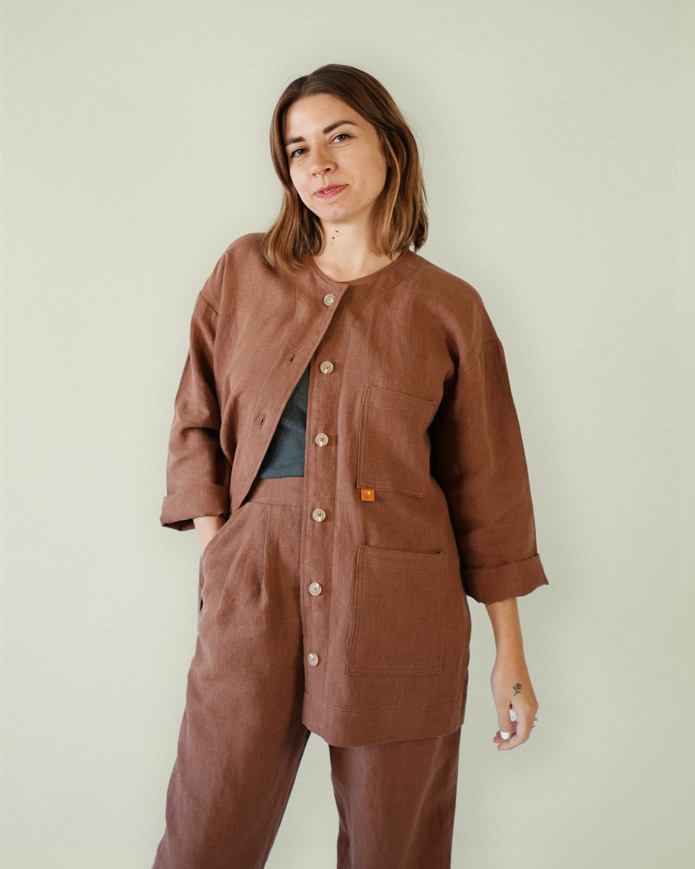 Woman wearing the Makers Over Shirt sewing pattern from Matchy Matchy on The Fold Line. An over shirt pattern made in light to medium weight woven fabrics, featuring a boxy silhouette, wide shoulder line, multiple pockets, front button placket, below hip 