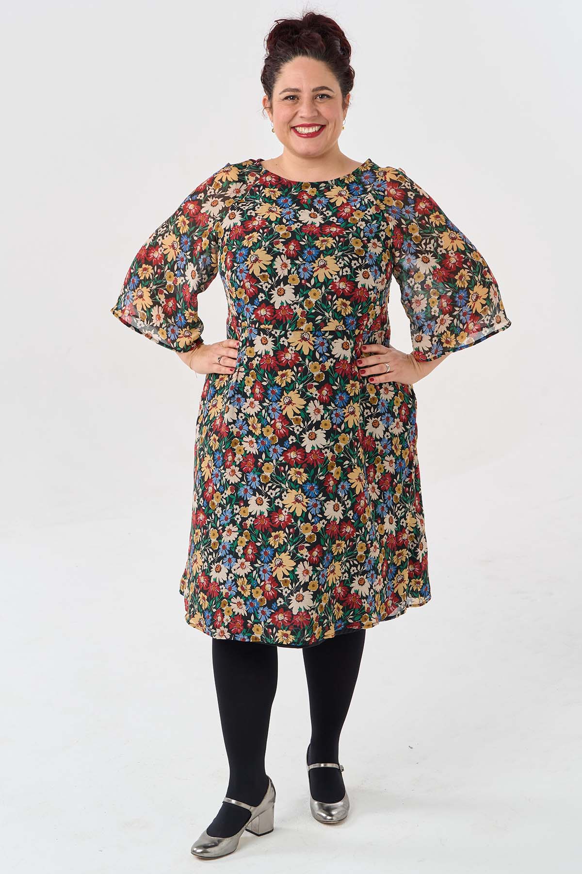 Woman wearing the Margot Dress sewing pattern from Sew Over It on The Fold Line. A dress pattern made in viscose, crepe, or chiffon fabric, featuring raglan 3/4 length bell sleeves, a lined bodice, French darts, an invisible side zip, and below the knee s