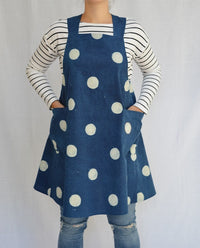 Woman wearing the Maria Apron sewing pattern from Maven Patterns on The Fold Line. An apron pattern made in denim, chambray or linen fabric, featuring a wrap style back, crossover straps and two large patch pockets.