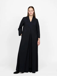 Woman wearing the Maxi Jumpsuit sewing pattern from The Assembly Line on The Fold Line. A jumpsuit pattern made in light to medium weight fabrics, featuring a V-neck, wide legs, mid front box pleat, side seam pockets, and invisible back zip closure.