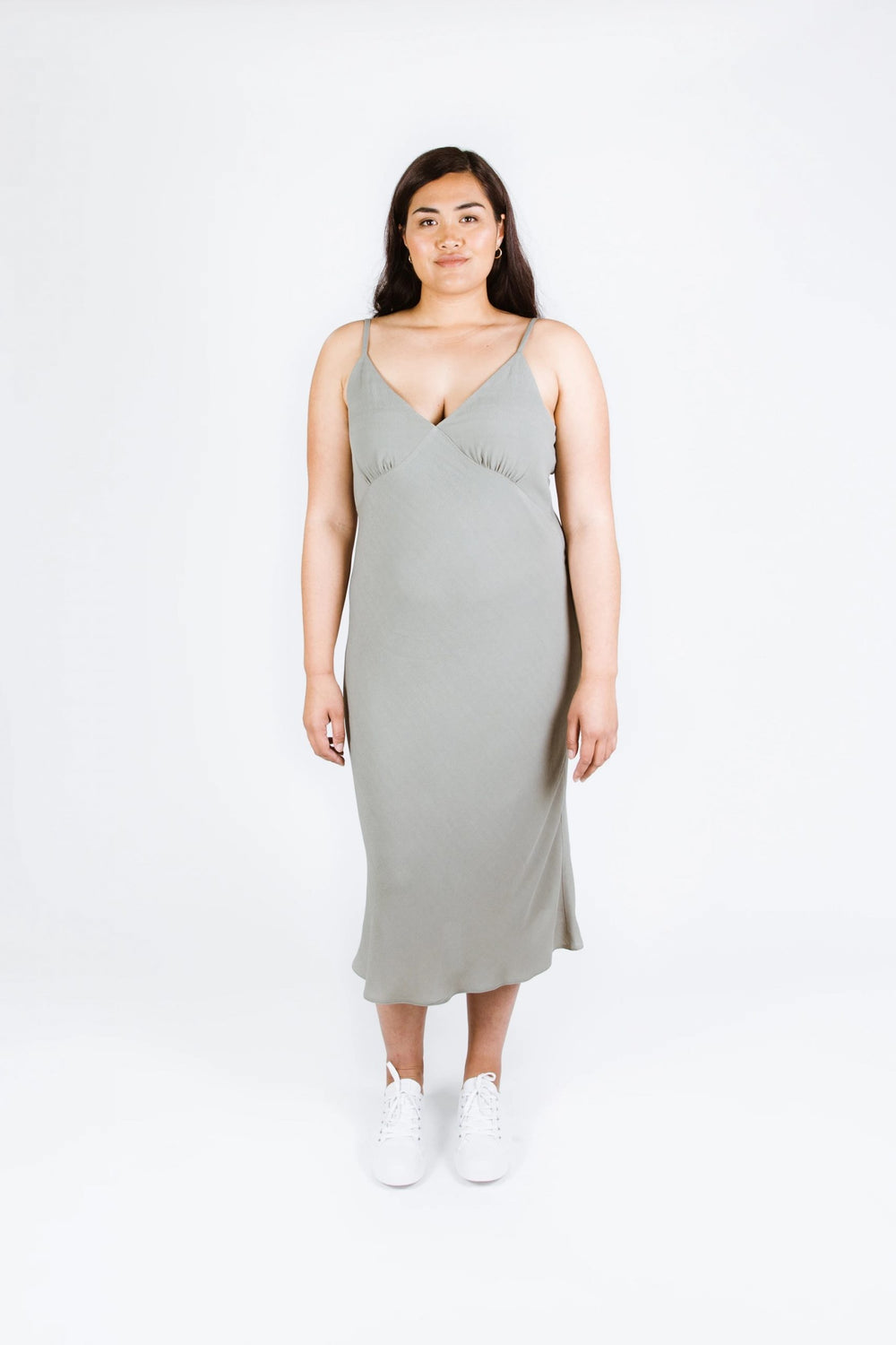 Woman wearing the Maya Dress sewing pattern from Papercut Patterns on The Fold Line. A cami dress pattern made in crepe de chine, rayon or silk fabrics, featuring a bias cut, spaghetti straps, deep V-neckline, gathered bust cup, and midi length.