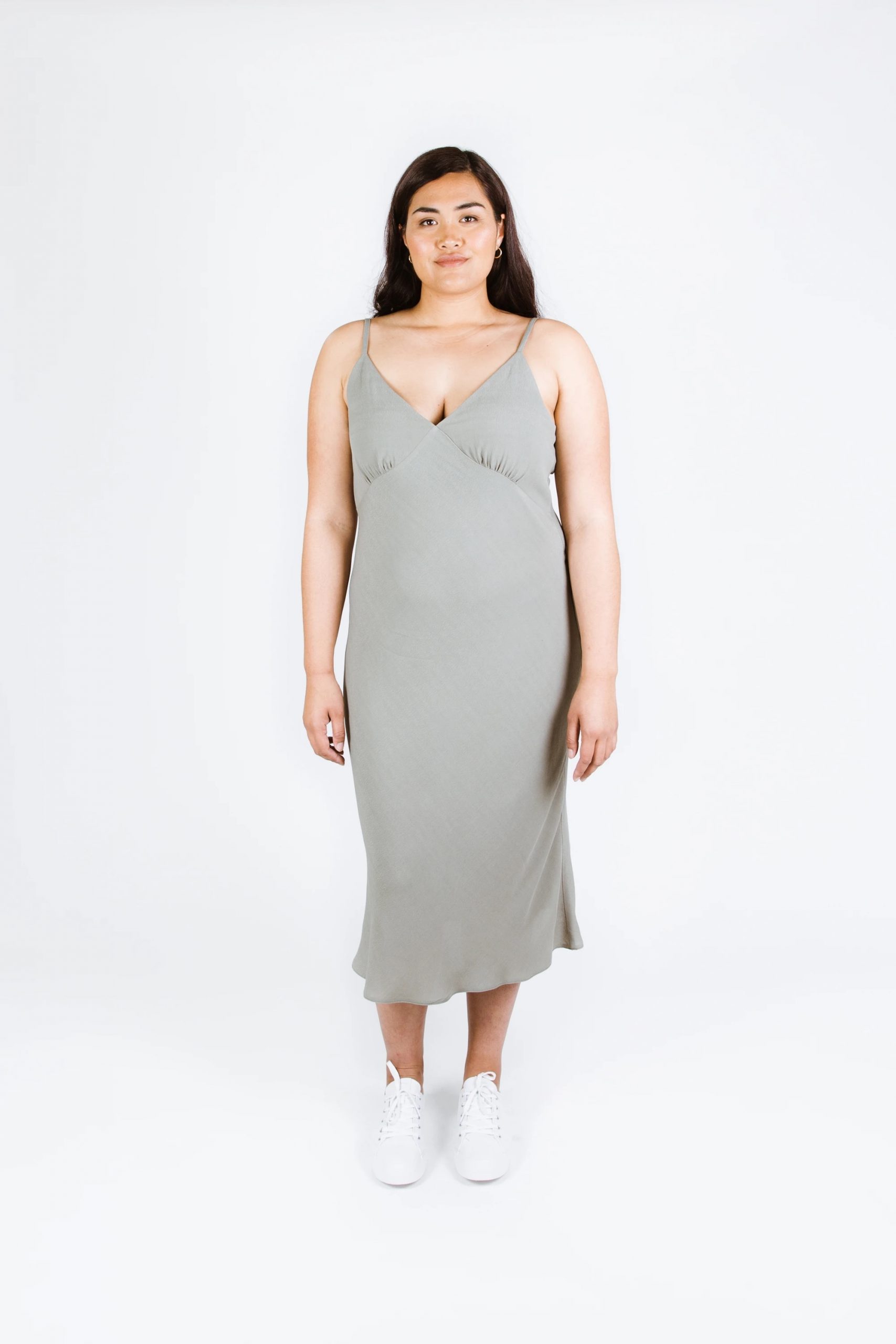 Woman wearing the Maya Dress sewing pattern from Papercut Patterns on The Fold Line. A cami dress pattern made in crepe de chine, rayon or silk fabrics, featuring a bias cut, spaghetti straps, deep V-neckline, gathered bust cup, and midi length.