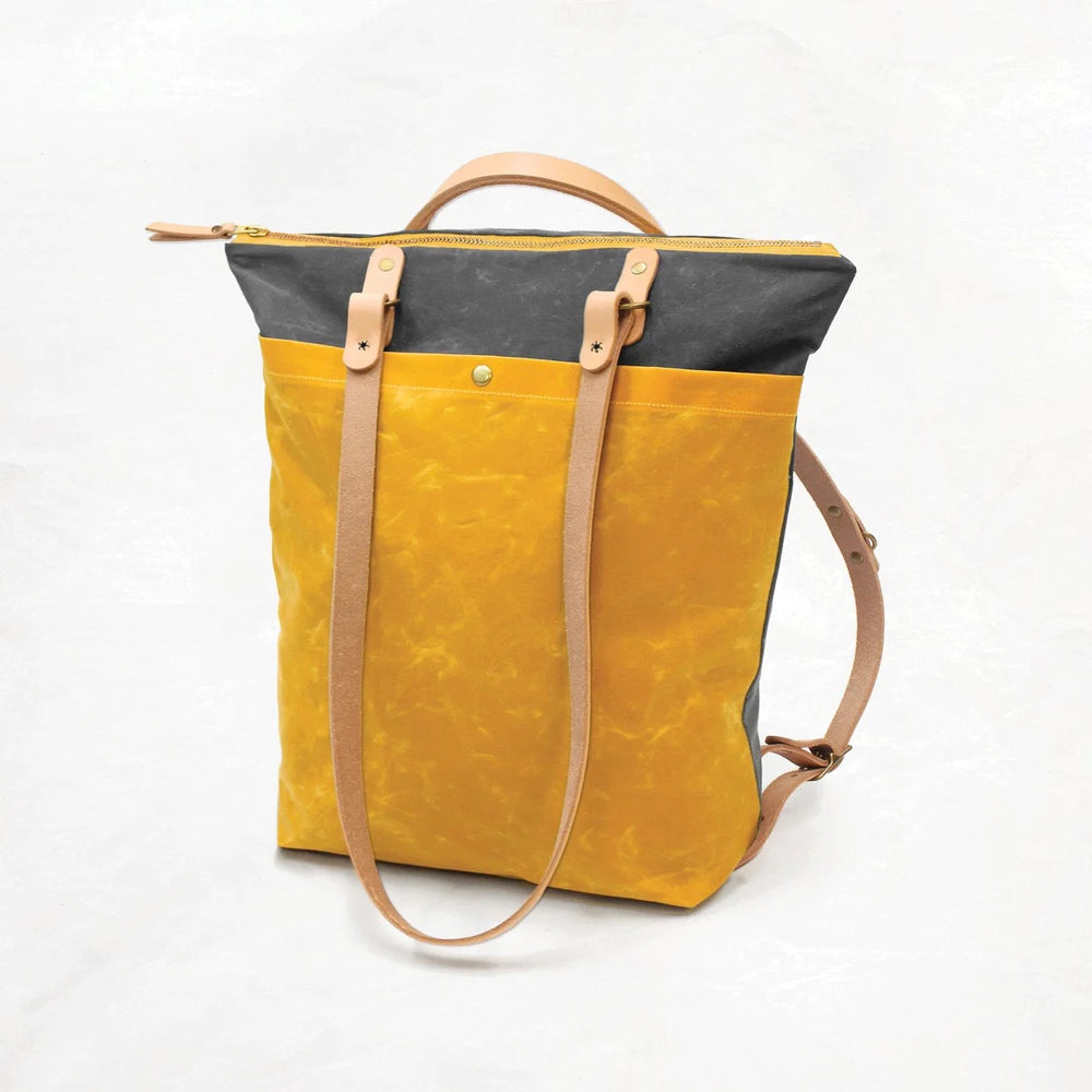 Photo showing the Maywood Totepack sewing pattern from Klum House on The Fold Line. A totepack pattern made in canvas, waxed canvas, or denim fabrics, featuring leather straps, zipper closure, exterior pocket with magnetic snap, and interior pocket large 