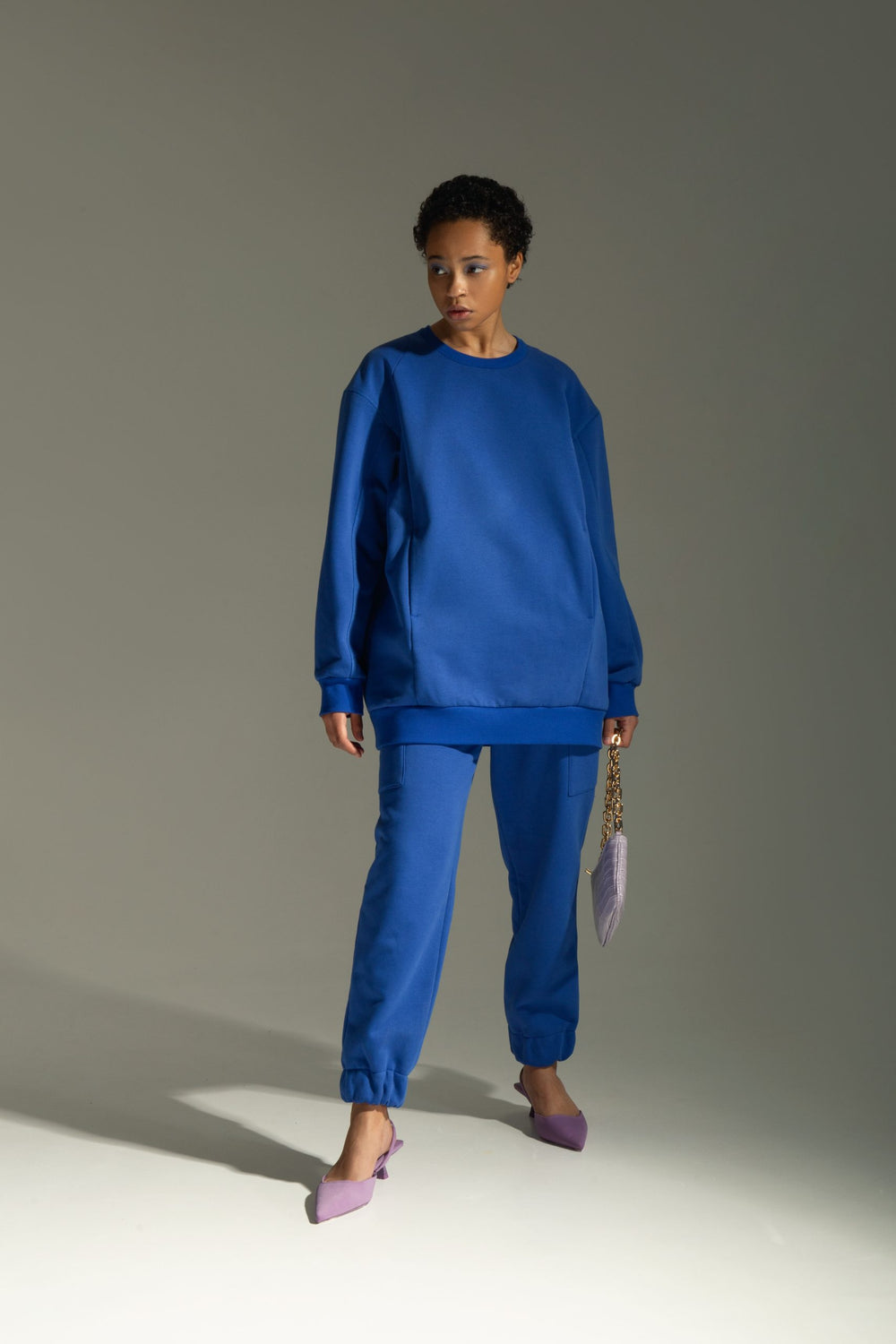 Woman wearing the Meg Sweatshirt sewing pattern from Vikisews on The Fold Line. A sweatshirt pattern made in sweatshirt fleece, thick french terry, or ponte di roma fabrics, featuring an oversized straight-cut, princess seams, side pockets, dropped should