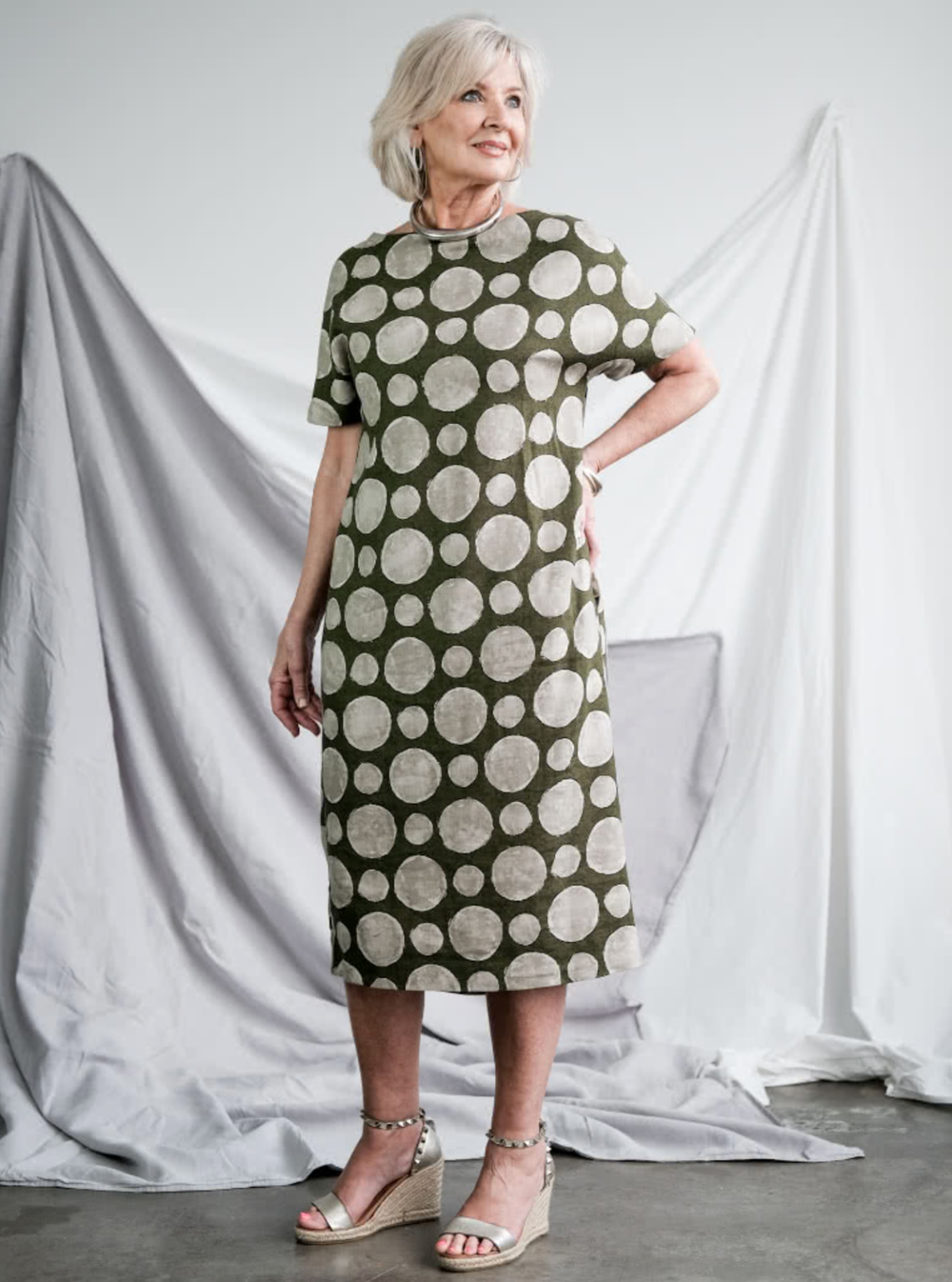 Woman wearing the Melba Dress sewing pattern from Style Arc on The Fold Line. A dress pattern made in Ponte, rugby knit, crepe or light wool fabrics, featuring a mid-length, pull-on style with slight cocoon shape, boat neck, extended shoulder line, short 