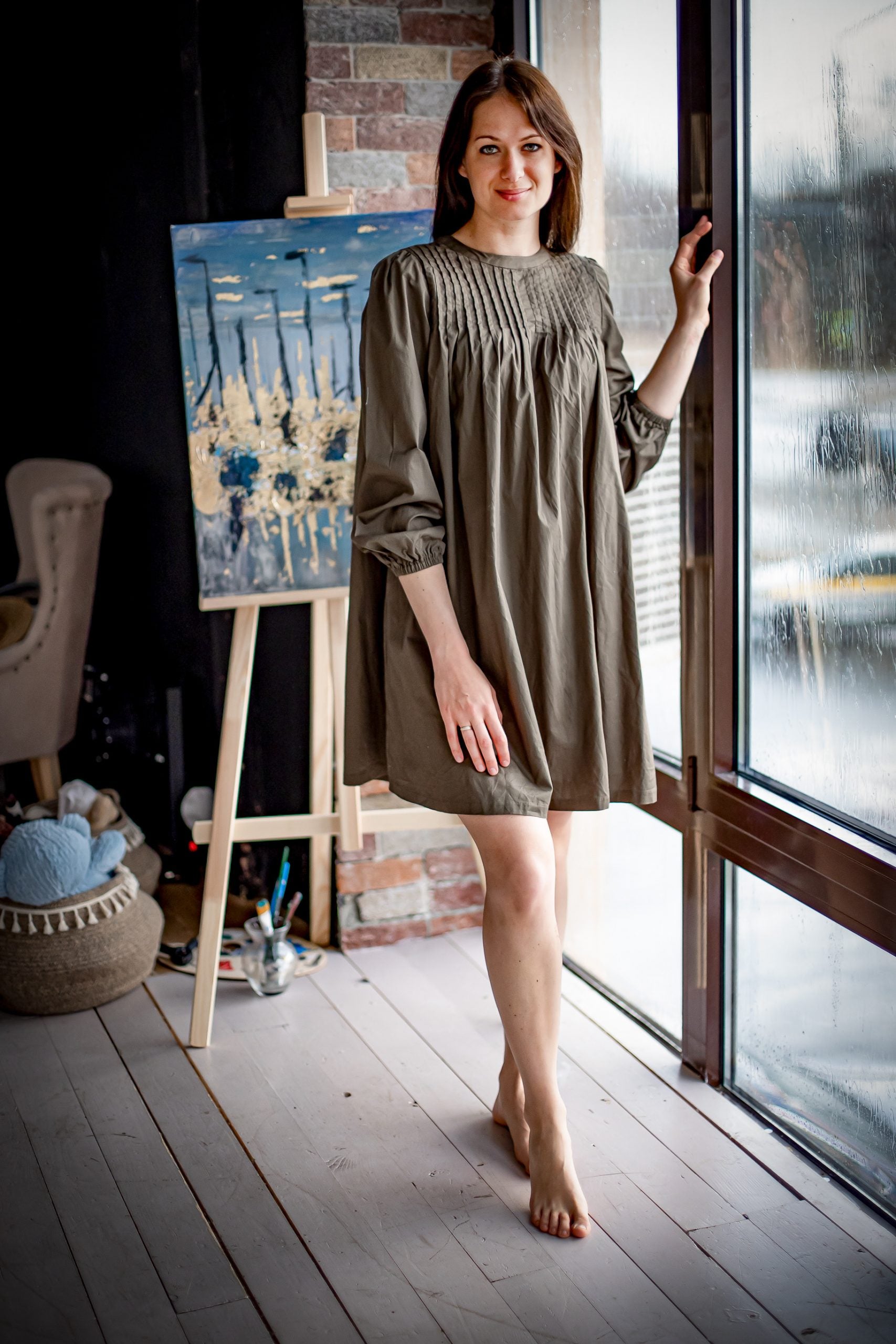 Woman wearing the Melissa Dress sewing pattern from Kates Sewing Patterns on The Fold Line. A flared dress pattern made in cotton or linen fabrics, featuring gathered full length sleeves with elasticated cuffs, mini length, back button and placket closure