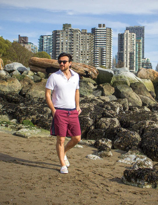 Man wearing the Men's Bamberton Shorts sewing pattern from Thread Theory on The Fold Line. A shorts pattern made in linen, cotton, seersucker, cotton and linen blend, polyester, or nylon fabric, featuring a drawstring waistband, side seam panels, mock fly