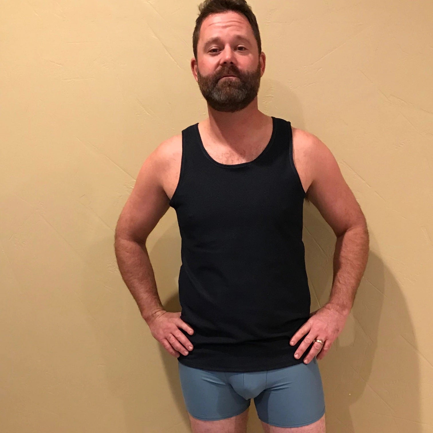 Man wearing the Men's Tank Top sewing pattern from Wardrobe by Me on The Fold Line. A track jacket pattern made in jersey fabric with lycra or stretchy rib fabrics, featuring a straight fitted body with binding at the round neckline and armscye.