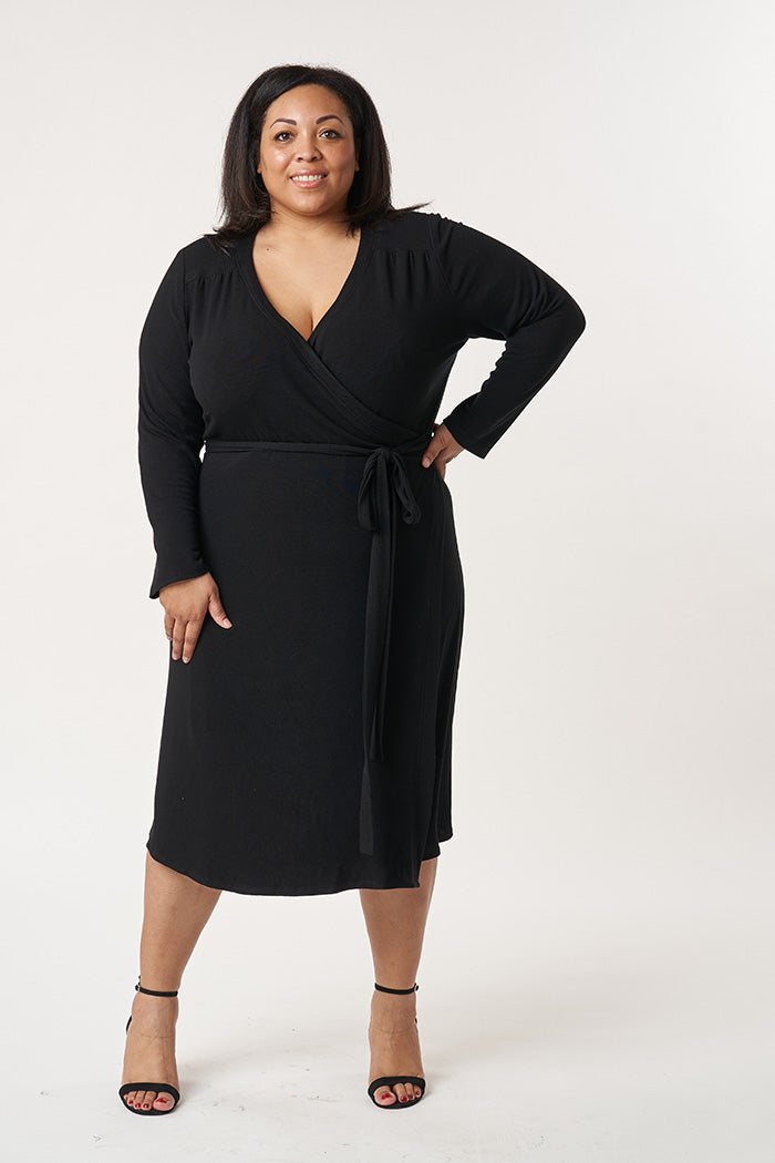 Woman wearing the Meredith Dress sewing pattern from Sew over It on The Fold Line. A wrap dress pattern made in light to medium weight knit fabrics, featuring full length sleeves, deep V-neck, self-fabric tie belt, midi length finish, shoulder yoke with g