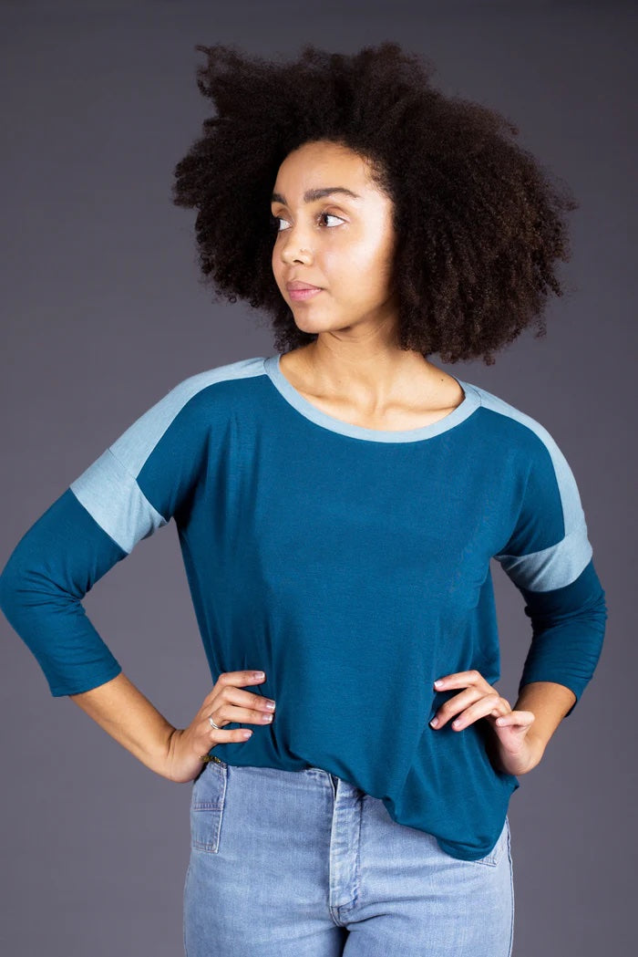 Woman wearing the Merlo Field Tee sewing pattern from Sew House Seven on The Fold Line. A T-shirt pattern made in jersey fabrics, featuring a wide oversized body, contrast stripes on the shoulder and arm, round neck and 3/4 length sleeves.