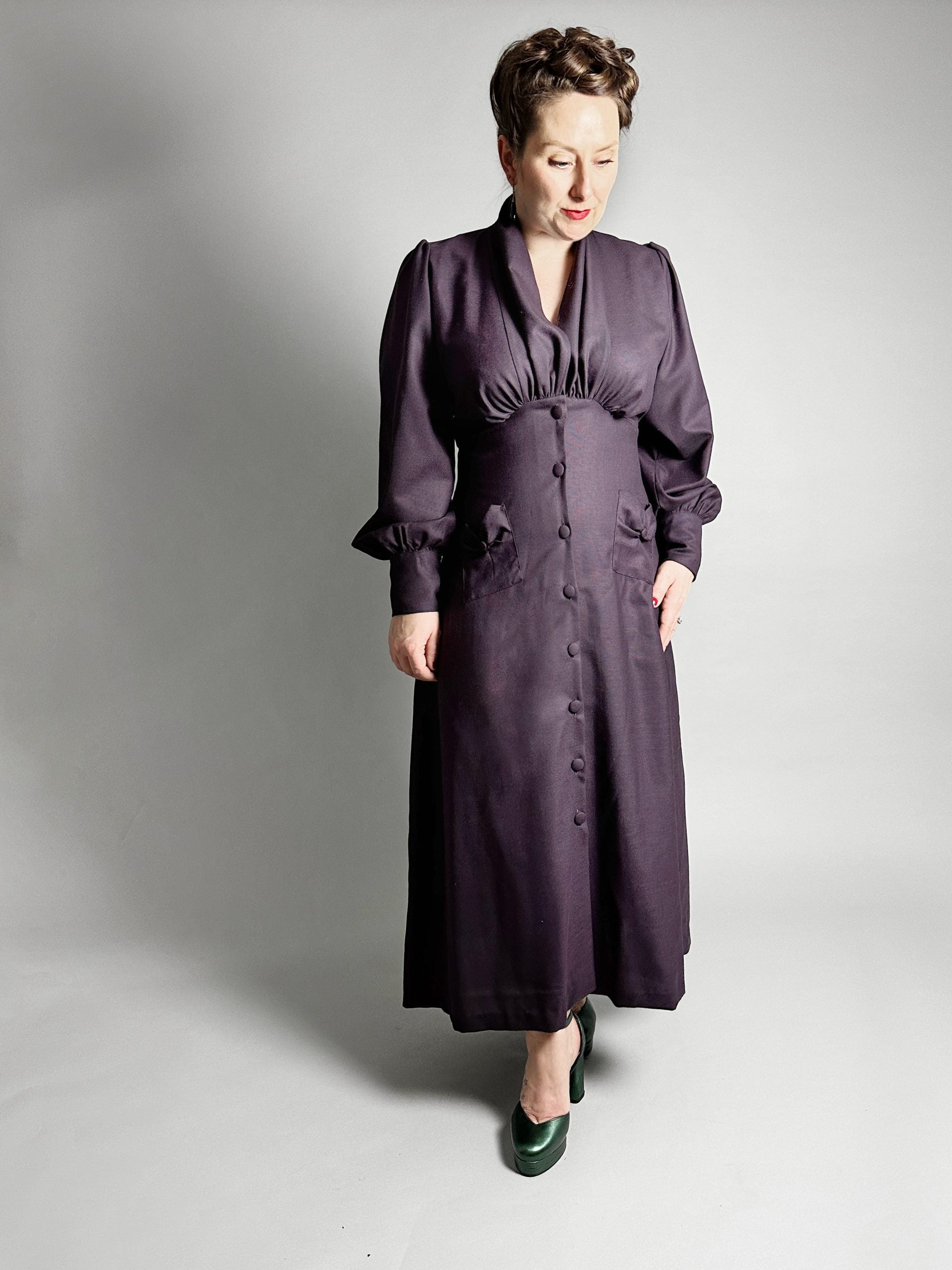 Woman wearing the No. 29 Milano Dress/Blouse sewing pattern from How to Do Fashion on The Fold Line. A dress pattern made in cotton, silk, wool, viscose, cupro, linen or polyester fabrics, featuring an empire line, high collar with gathers, deep V-neck, l