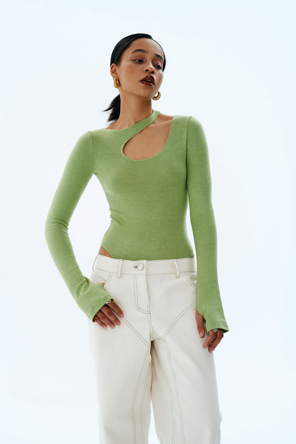 Woman wearing the Miley Bodysuit sewing pattern from Vikisews on The Fold Line. A bodysuit pattern made in sweater knits, rib knits, and ponte di roma fabrics, featuring a close-fit, asymmetric neckline with shaped cutout on the left shoulder, set-in slee
