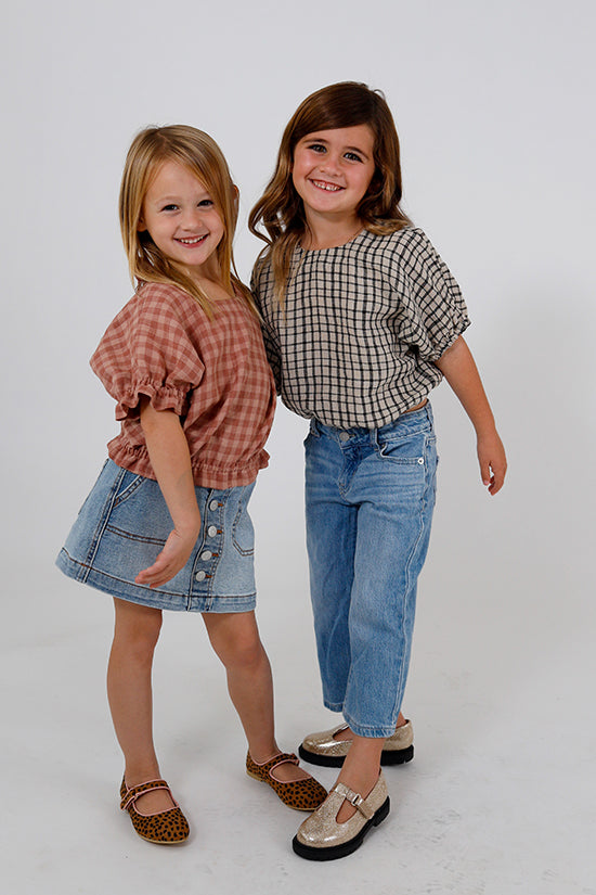 Children wearing the Baby/Child Mini Aria Top sewing pattern from Chalk and Notch on The Fold Line. A top pattern made in challis, chambray, double gauze, lawn, linen, voile fabrics, featuring a bubble-shape, elasticated elbow-length sleeves with optional
