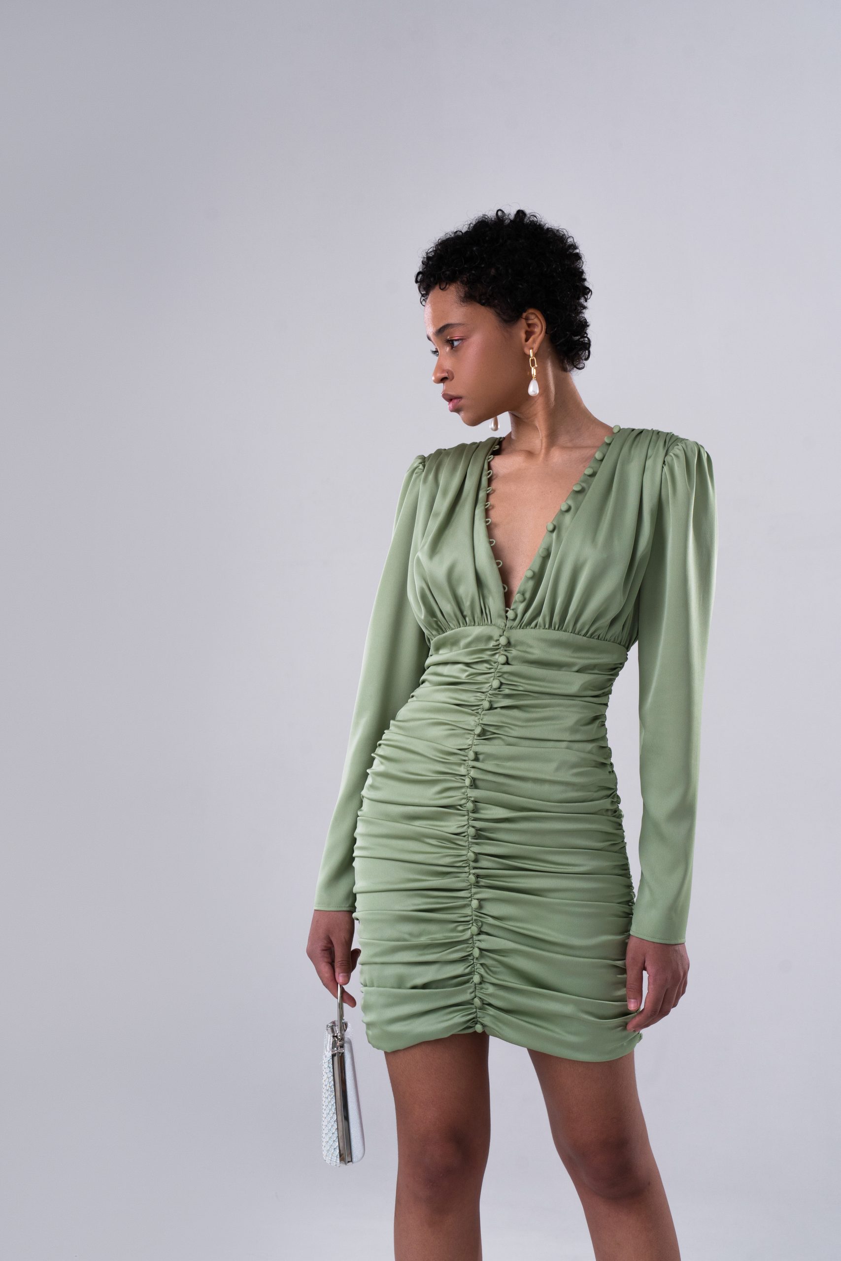 Woman wearing the Mirella Dress sewing pattern from Vikisews on The Fold Line. A dress pattern made in natural silk, crepe, artificial silk, crinkle chiffon, crepe de chine or lightweight knit fabrics, featuring a close-fit, shoulder pads, long set-in sle
