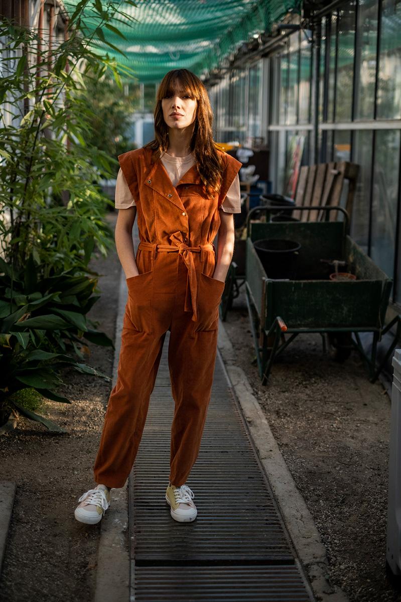 Woman wearing the Moira Jumpsuit sewing pattern from Fibre Mood on The Fold Line. A trouser pattern made in denim, corduroy, suede, gabardine or cotton twill fabrics, featuring a rounded square neck, top stitching, winged sleeves, snap closure, balloon le