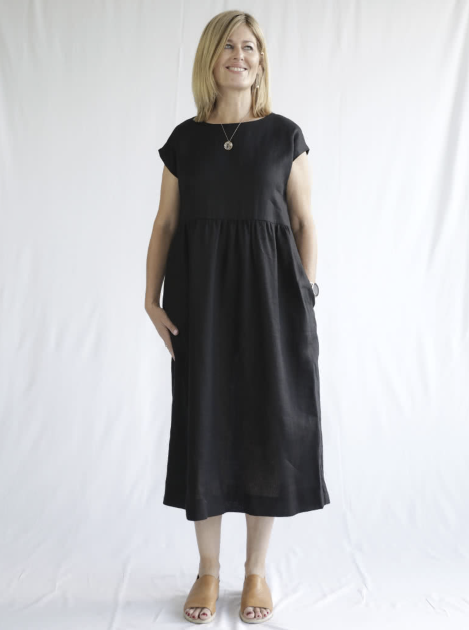 Woman wearing the Montana Midi Dress sewing pattern from Style Arc on The Fold Line. A dress pattern made in washed linen, rayon, crepe or knit fabrics, featuring a pull-on style, extended shoulder line, loose silhouette, high waist with slight gathers, i