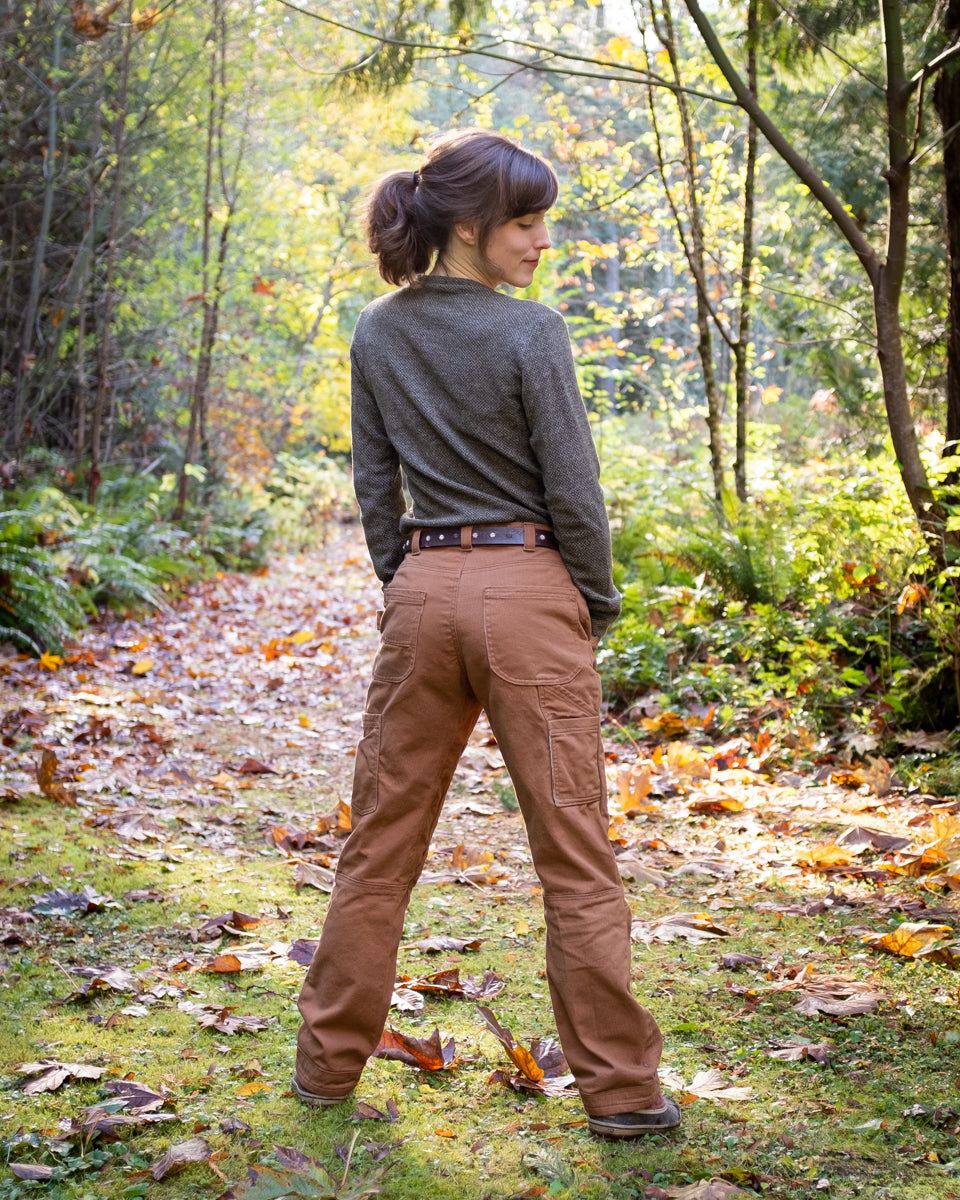 Woman wearing the Morden Work Pants sewing pattern Thread Theory on The Fold Line. A trouser pattern made in twill, denim, canvas, gabardine or ripstop fabrics, featuring roomy legs, knee darts, close-fitting gusset, front, side and back pockets, belt loo