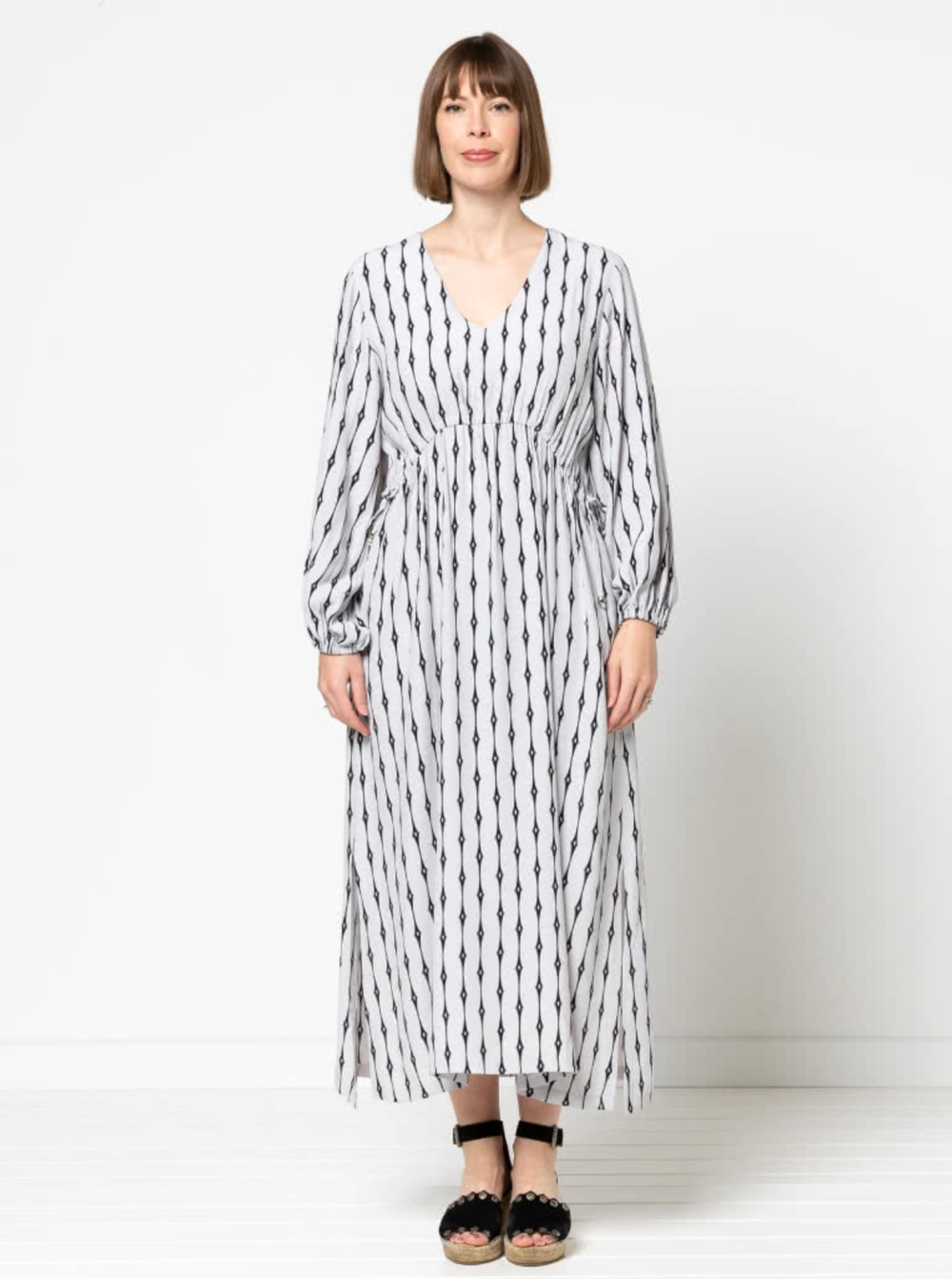 Woman wearing the Naomi Woven Dress sewing pattern from Style Arc on The Fold Line. A dress pattern made in rayon, crepe or silk fabrics, featuring a slip-on style, V-neck, angled waist seam with drawstring, 7/8-length sleeves with elasticated cuffs, side