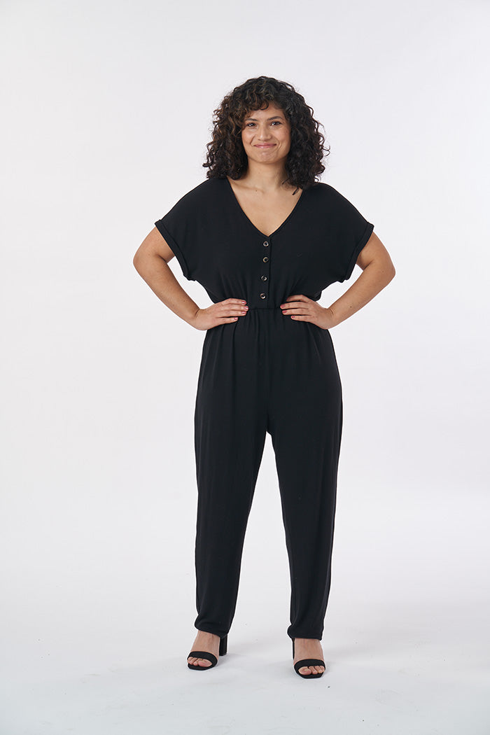 Woman wearing the Nasima Jumpsuit sewing pattern from Sew Over It on The Fold Line. A jumpsuit pattern made in cotton jersey, bamboo, viscose, cotton/elastane or cotton/polyester/spandex jersey blends fabrics, featuring grown on sleeves with short cuffs, 