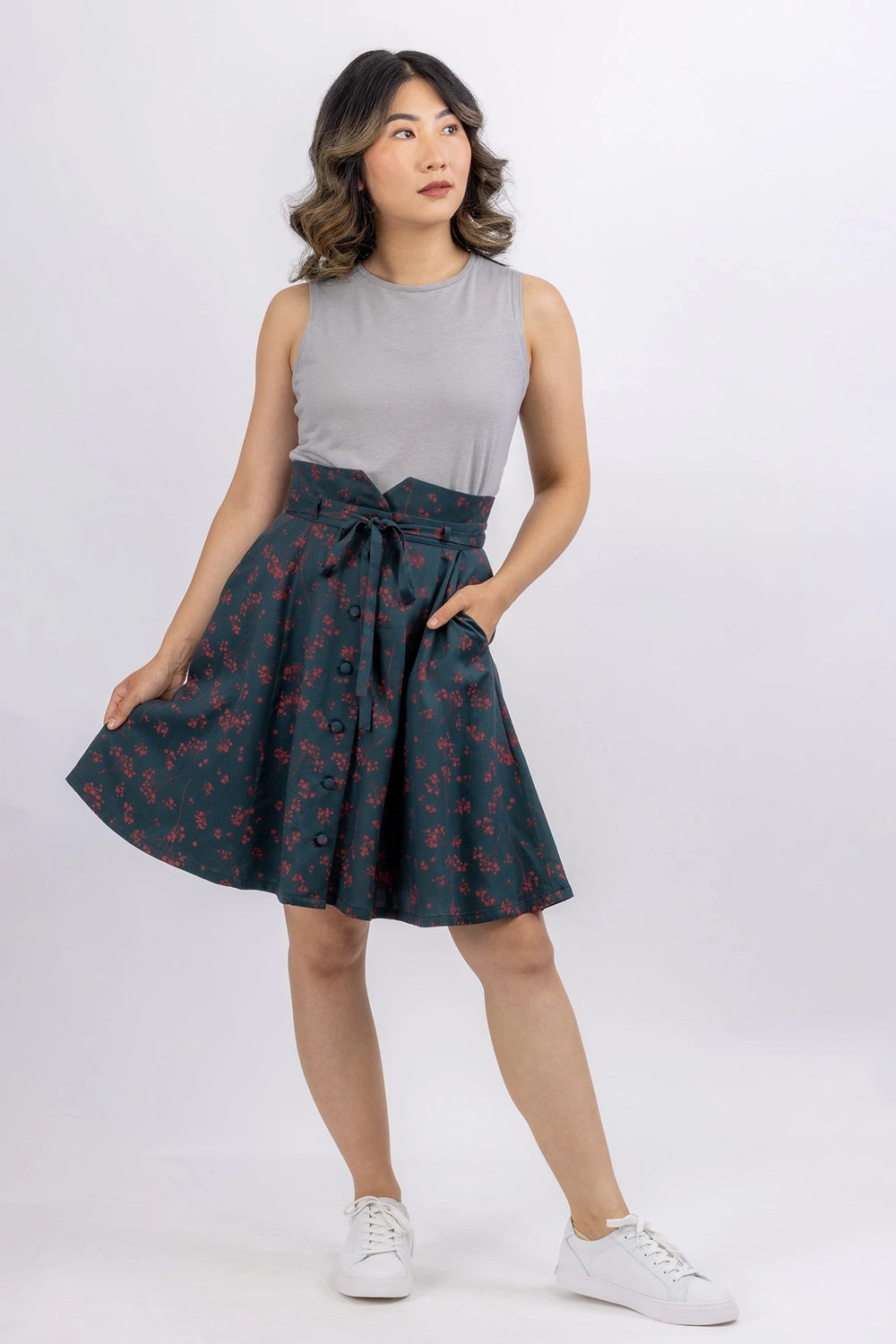 Woman wearing the Natalie Skirt sewing pattern from Forget-me-not Patterns on The Fold Line. A skirt pattern made in cotton chambray, cotton voile, linen, denim or stable viscose/rayon fabrics, featuring a button-front, gored style lines, slash pockets, r