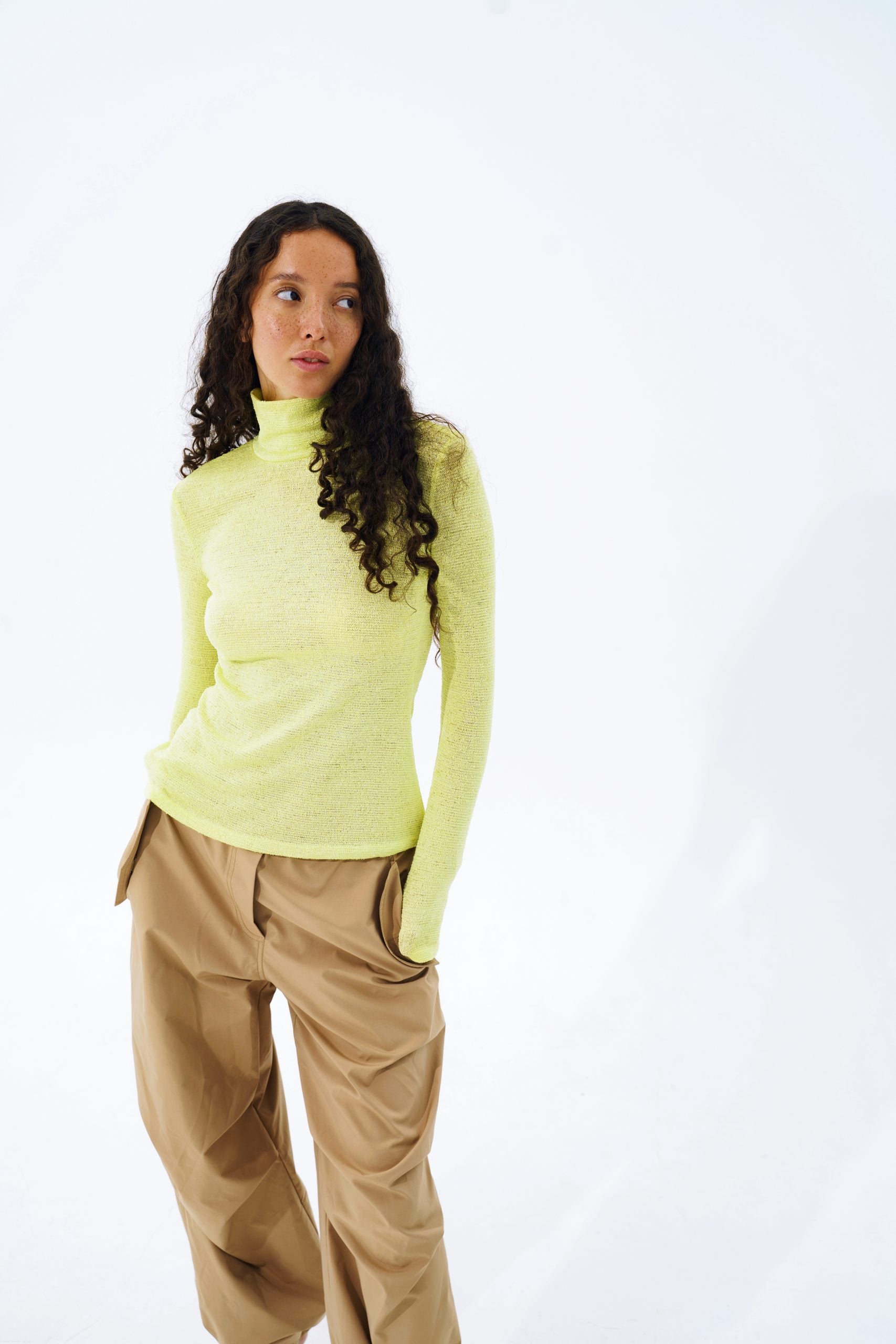 Woman wearing the Nettie High Neck Sweater sewing pattern from Vikisews on The Fold Line. A sweater pattern made in sweater knits, rib knits or jersey fabrics, featuring a close-fit, high neck, long set-in sleeves, two-layer stand-up collar and hip-length