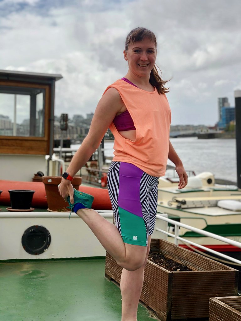 Woman wearing the Duathlon Shorts sewing pattern from Fehr Trade on The Fold Line. An activewear shorts pattern made in Lycra Jersey fabrics, featuring a close-fit, contrast side panels, above knee length, hip integrated pockets, optional padding piece fo