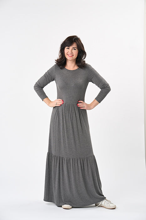 Woman wearing the Nomi Dress sewing pattern from Sew Over It on The Fold Line. A knit dress pattern made in viscose or bamboo jersey, French terry or lightweight cotton jersey fabrics, featuring a crew neckline, long sleeves, gathered skirt that falls jus