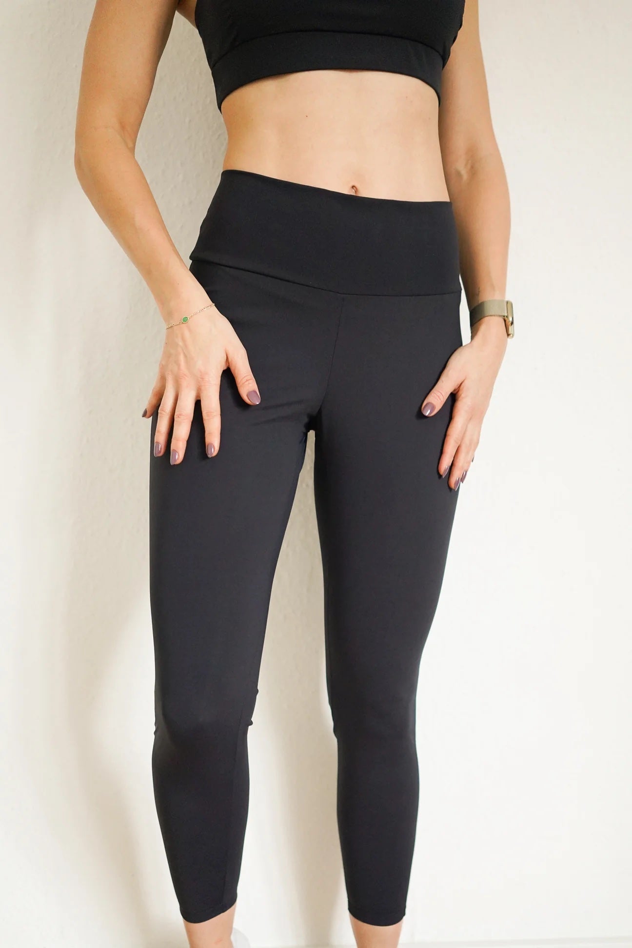 Woman wearing the Nora Leggings sewing pattern from Bara Studio on The Fold Line. A leggings pattern made in Bi-stretch fabrics, featuring a high waist, wide waistband, cropped length and shaped back seam.