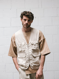 Man wearing the Men's Benson Utility Vest sewing pattern from Notches on The Fold Line. A vest pattern made in canvas, twill, denim, corduroy, nylon, quilted, or teddy fabric, featuring a straight fit, zip front, and pockets with flaps.