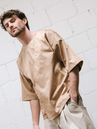 Man wearing the Men's Jack Shirt sewing pattern from Notches on The Fold Line. A shirt pattern made in cotton or linen fabric, featuring a round neckline, elbow length sleeves, and an overlapping front panel.