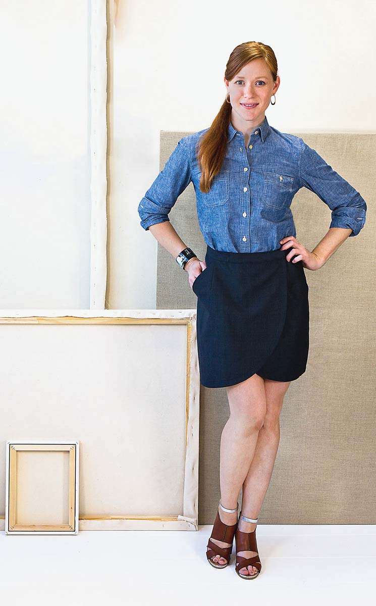 Woman wearing the City Stroll Wrap Skirt sewing pattern from Liesl + Co on The Fold Line. A skirt pattern made in chambray, lightweight canvas, sateen, twill, wool suiting, crepe, and brocade fabrics, featuring front slant pockets, curved hem, above knee 