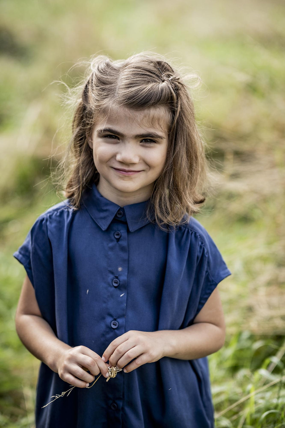 Child wearing the Odille Dress sewing pattern from Fibre Mood on The Fold Line. A dress pattern made in viscose (crepe), poplin, linen, lyocell or chambray fabrics, featuring an oversized silhouette, dropped short sleeves, yoke with front and back gathers
