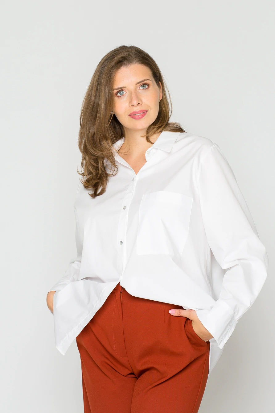 Woman wearing the Olivia Blouse sewing pattern from Bara Studio on The Fold Line. A blouse pattern made in viscose, cotton linen or tencel fabrics, featuring an oversized fit, classic shirt collar, button placket, chest patch pocket, back yoke, long sleev