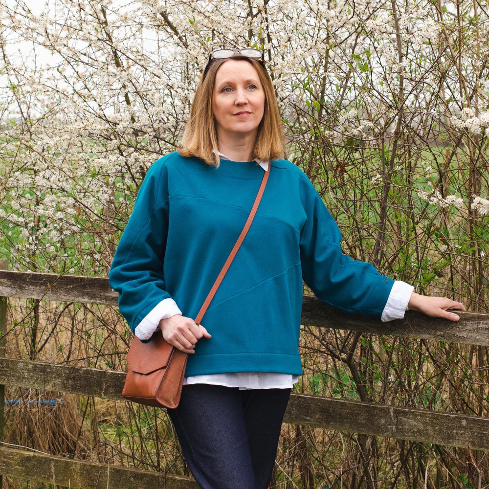 Woman wearing the Olivia Origami Sweatshirt sewing pattern from Sew Me Something on The Fold Line. A sweatshirt pattern made in fleece back sweatshirting, french terry or ponte roma fabrics, featuring grown on sleeves, round neck, relaxed fit, cocoon cuff
