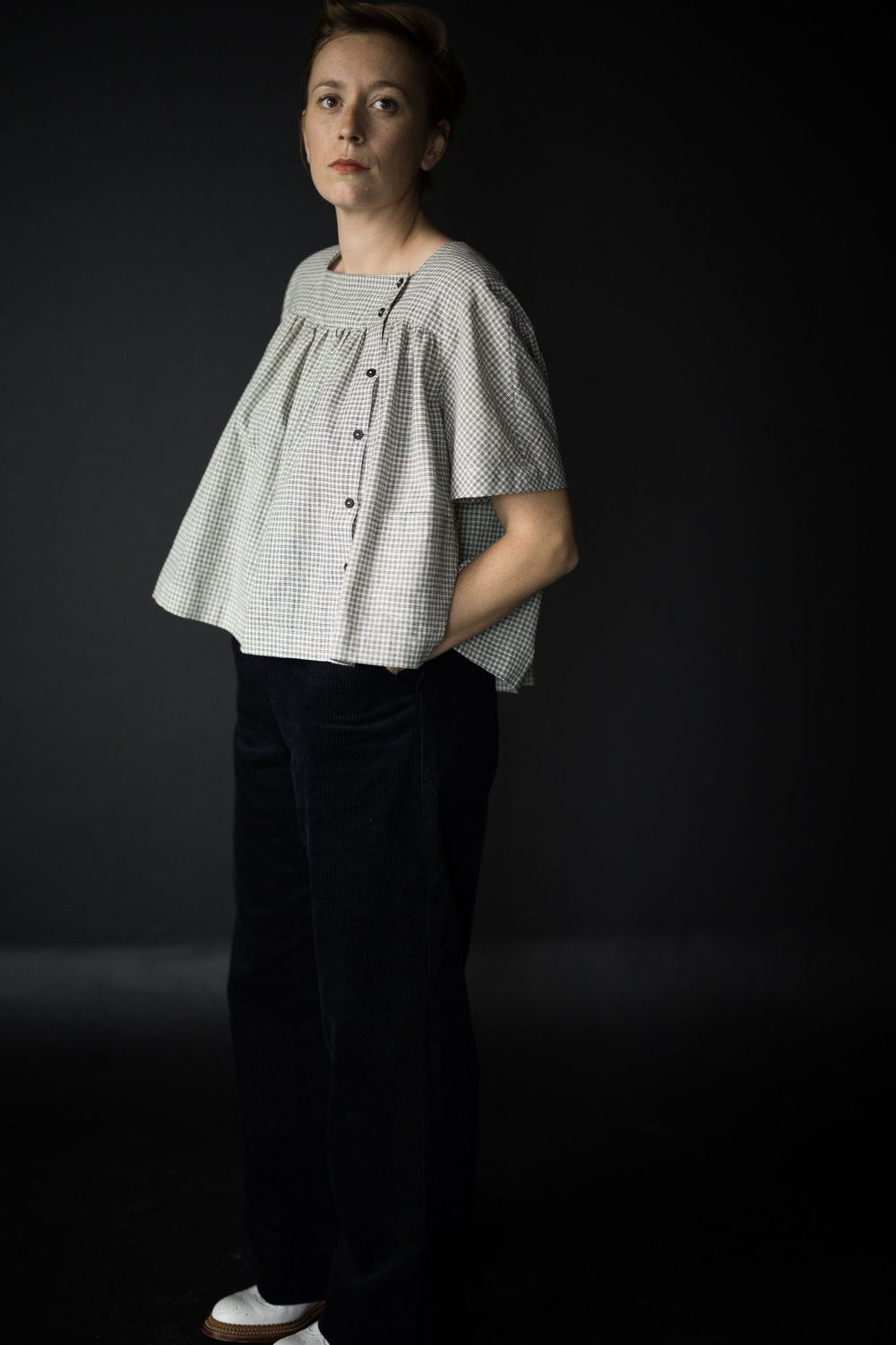 Woman wearing the The Omilie Top sewing pattern from Merchant & Mills on The Fold Line. A top pattern made in linen, brushed cotton, cotton lawn, cotton poplin, tencel, Indian handlooms, linen or cotton double gauze fabrics, featuring a smock style, patch