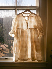 Photo of the Orchards Dress Expansion sewing pattern from Vivian Shao Chen on The Fold Line. A dress pattern made in cotton or linen fabric, featuring a loose fit, gathers at the neckline, a rounded collar, button placket, puff sleeves with pin tucks, and