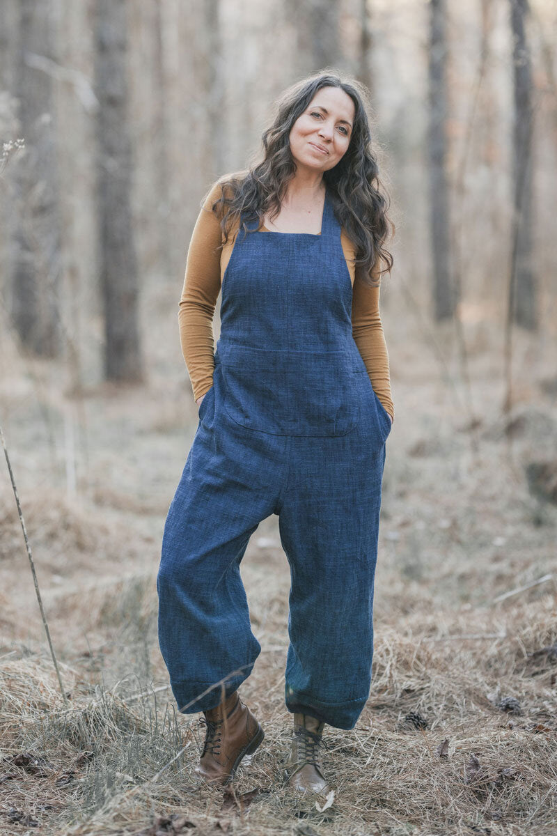 Woman wearing the Otis Overalls sewing pattern by Sew Liberated. A dungaree pattern made in mid-weight woven fabrics, such as linen, gabardine, lightweight twill or denim, linen or silk noil fabrics, featuring shaped seams on the lower leg and an ankle-le