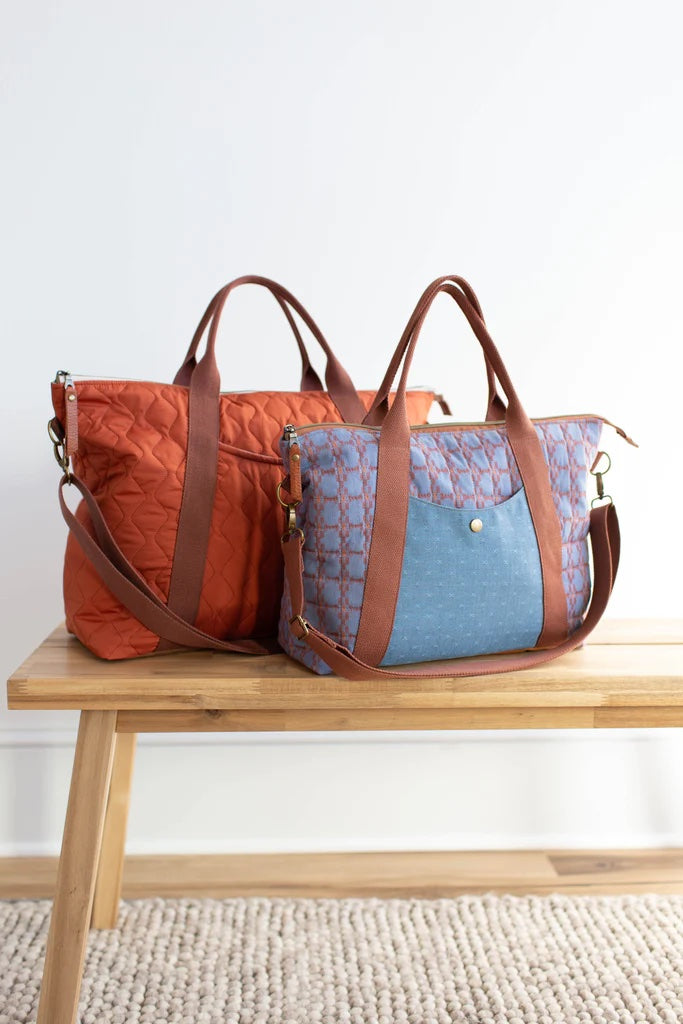 Photo showing the Oxbow Totes sewing pattern from Noodlehead on The Fold Line. A bag pattern made in dry oilskin/waxed or twill/waxed canvas fabrics, featuring a zip closure, two sizes, front pocket, reinforced base, removable crossbody strap, and roomy i