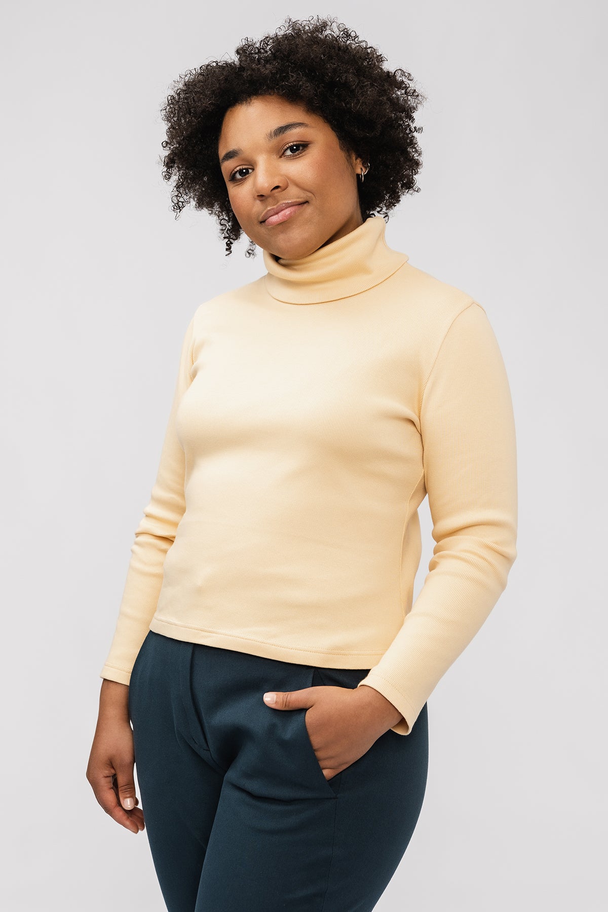 Woman wearing the Paola Turtleneck Tee sewing pattern from Named on The Fold Line. A jumper pattern made in light to medium weight knit fabrics, featuring a double fold turtleneck, and long sleeves.