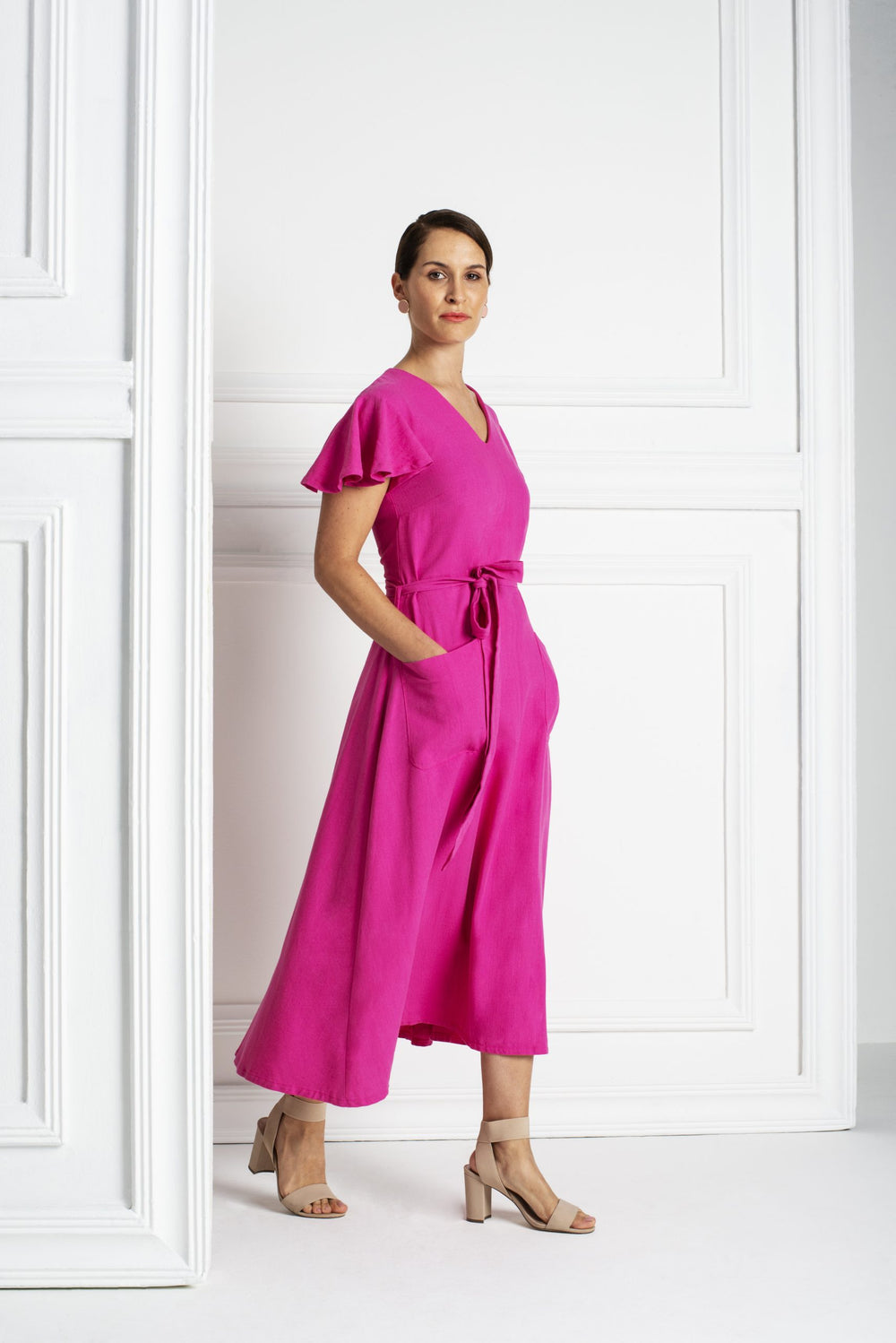 Woman wearing the Margot Dress sewing pattern from Pattern Sewciety on The Fold Line. A dress pattern made in cotton, cotton blends, linen, linen blends, rayon’s or satin fabrics, featuring a relaxed fit, V-neck, bust darts, waist seam, short circle sleev