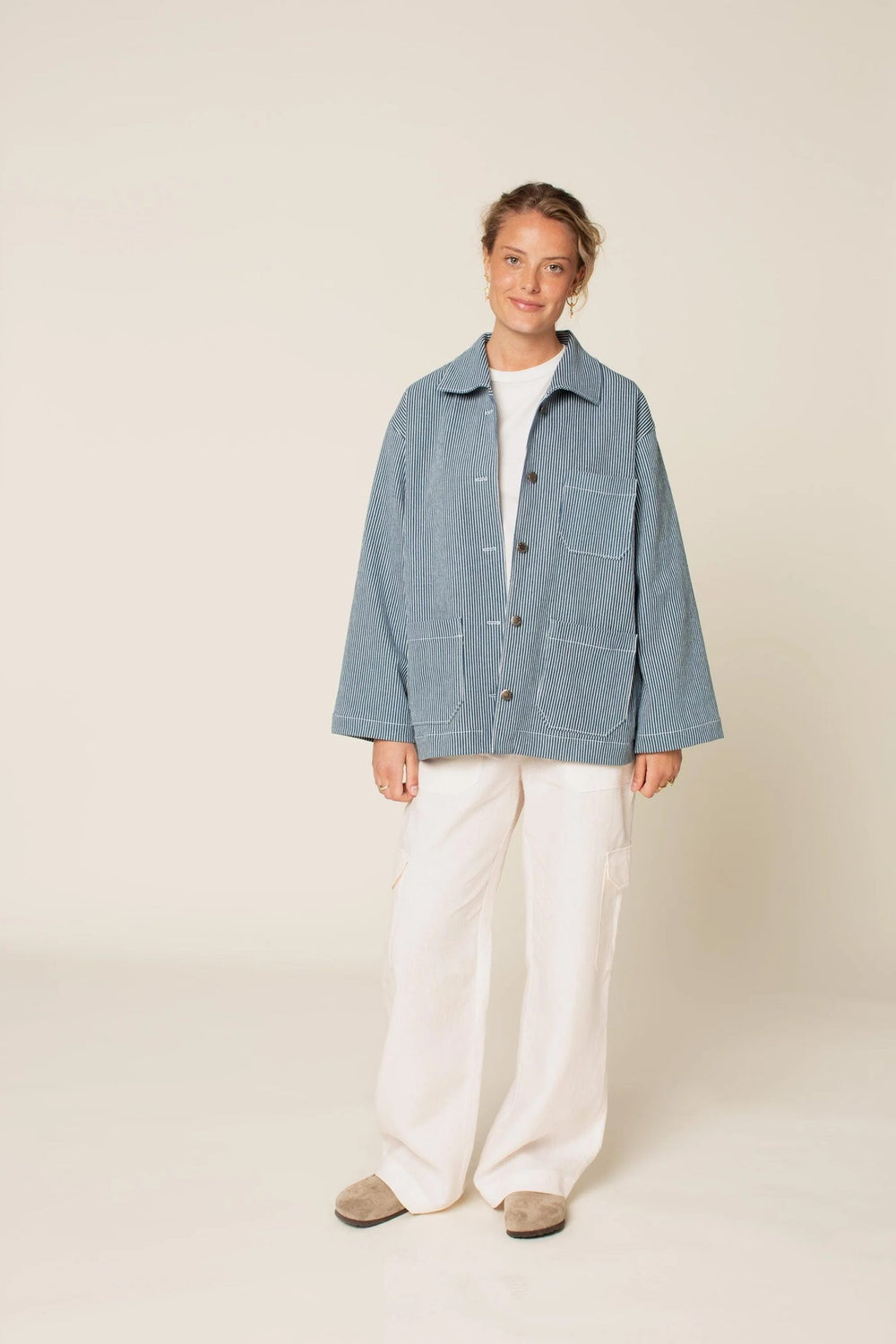 Woman wearing the Unisex Painter Jacket sewing pattern from Wardrobe by Me on The Fold Line. A jacket pattern made in denim, cotton drill, linen or wool fabrics, featuring an oversized fit, dropped shoulders, large convertible collar, three patch pockets,