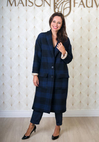 Woman wearing the Pam Coat sewing pattern from Maison Fauve on The Fold Line. A coat pattern made in wool, tweed or fake fur fabrics, featuring a wide cut, low armhole, V-neck, shawl collar, large patch pockets, maxi length, fully lined, turned back cuffs