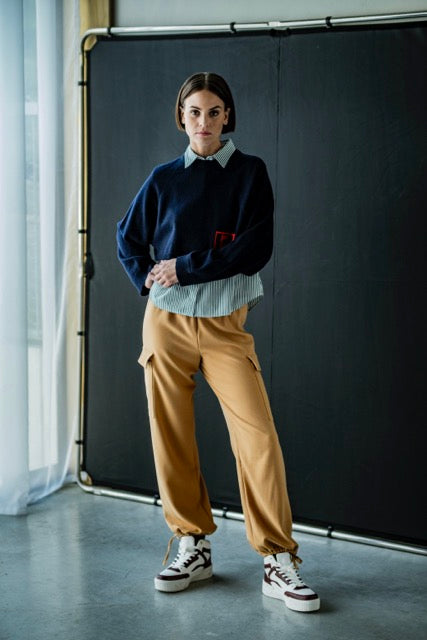 Woman wearing the Pax Trousers sewing pattern from Fibre Mood on The Fold Line. A cargo trouser pattern made in cotton twill, crepe, satin, nylon, faux leather, or French terry fabrics, featuring an elastic waist with drawstring, full length leg with hem 