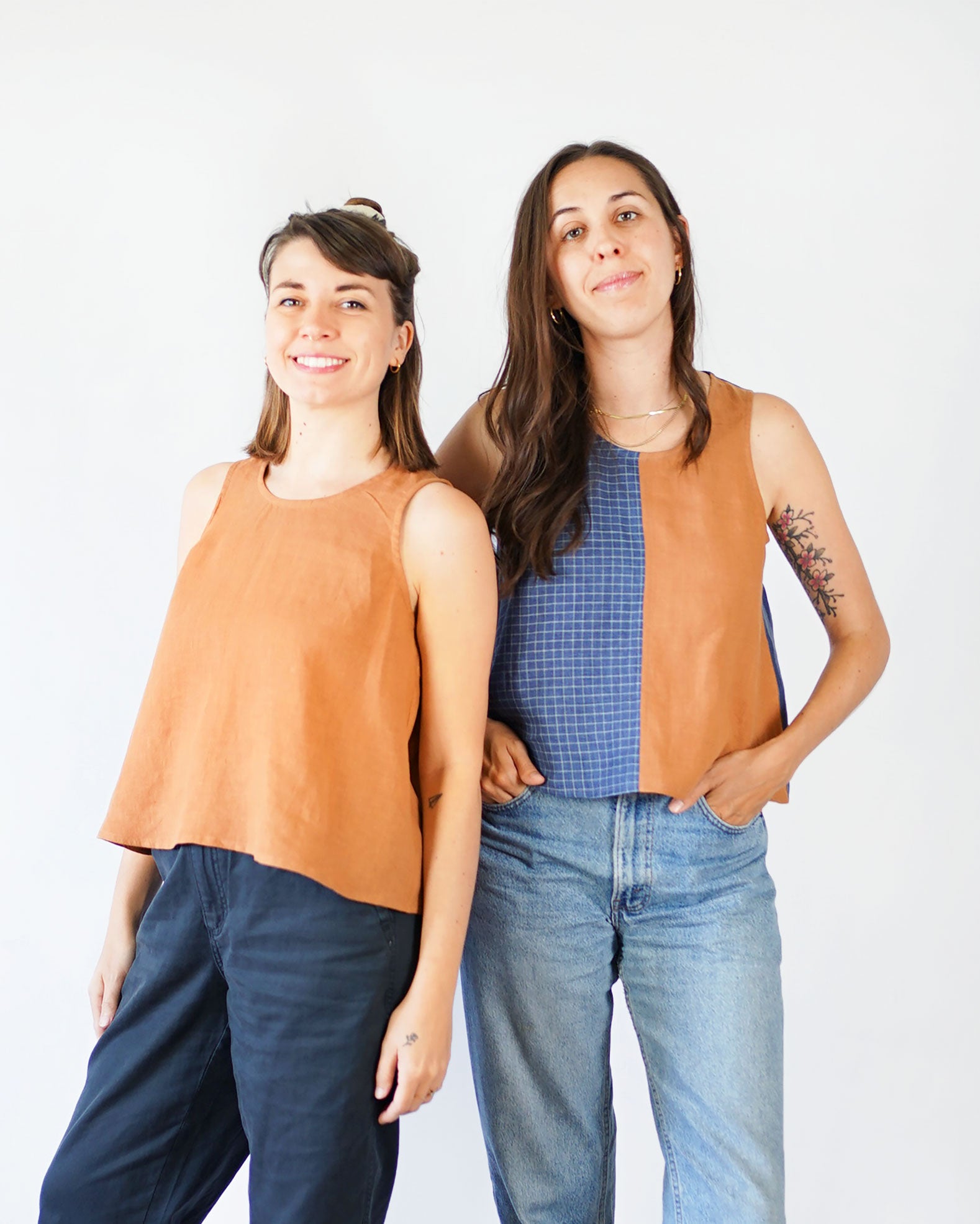 Women wearing the Peplum Split Tank sewing pattern from Matchy Matchy on The Fold Line. A tank pattern made in light to medium weight woven fabrics, featuring an A-line silhouette, scoop neck, high gathered peplum at back, cropped length, dart free, and o