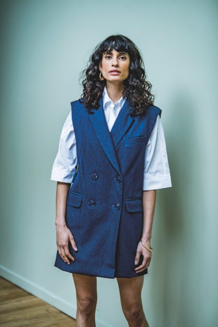 Woman wearing the Perla Dress sewing pattern from Fibre Mood on The Fold Line. A sleeveless dress pattern made in cotton twill, polycotton, denim, linen or woollen fabrics such as tweed, flannel and fine virgin wool, featuring an oversized fit and blazer-