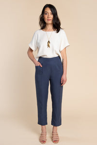 Woman wearing the Pietra Pants sewing pattern by Closet Core Patterns. A trouser pattern made in linen, chambray, lightweight denim or twill fabric featuring a flat front, high waist with elastic at the back and slanted hip pockets.