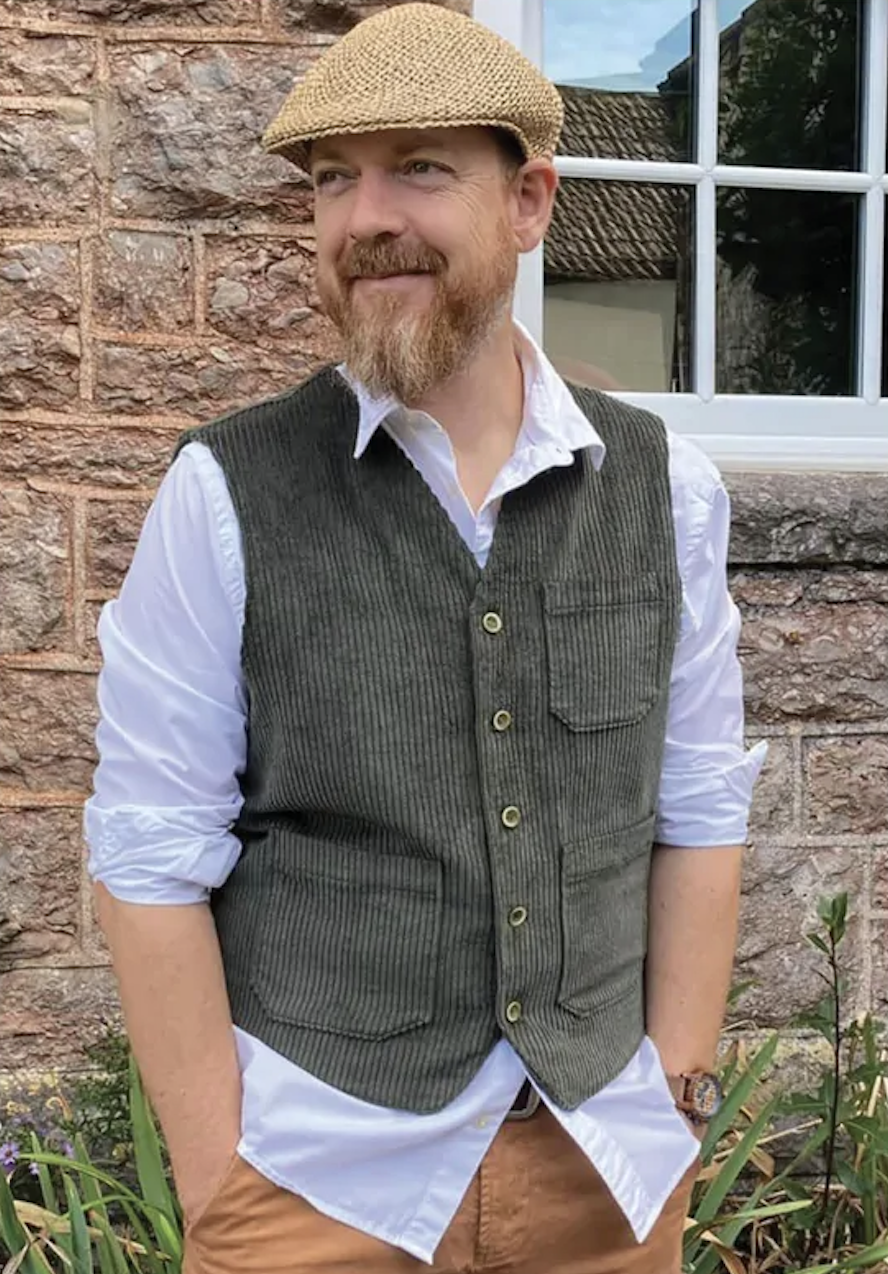 Man wearing the Men's Pike's Vest sewing pattern from Wardrobe by Me on The Fold Line. A waistcoat pattern made in cotton, linen, corduroy or wool fabrics, featuring patch pockets, back darts, shaped centre seam, front slightly longer that the back, fully