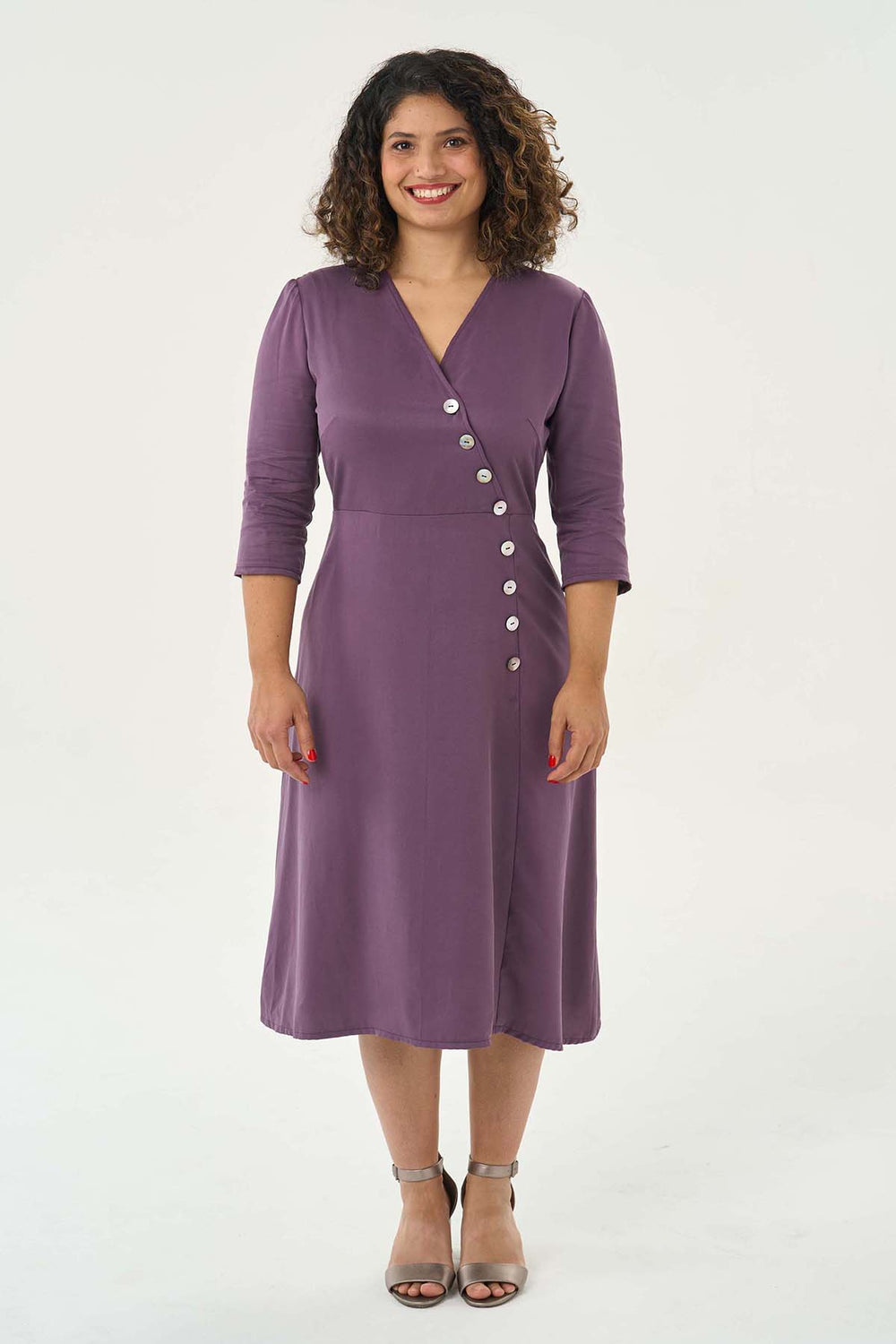 Woman wearing the Pippa Dress sewing pattern from Sew Over It on The Fold Line. A dress pattern made in rayon, viscose and crepe fabrics, featuring a front asymmetrical line of buttons, bust darts, back bodice waist darts, side invisible zip closure, V-ne