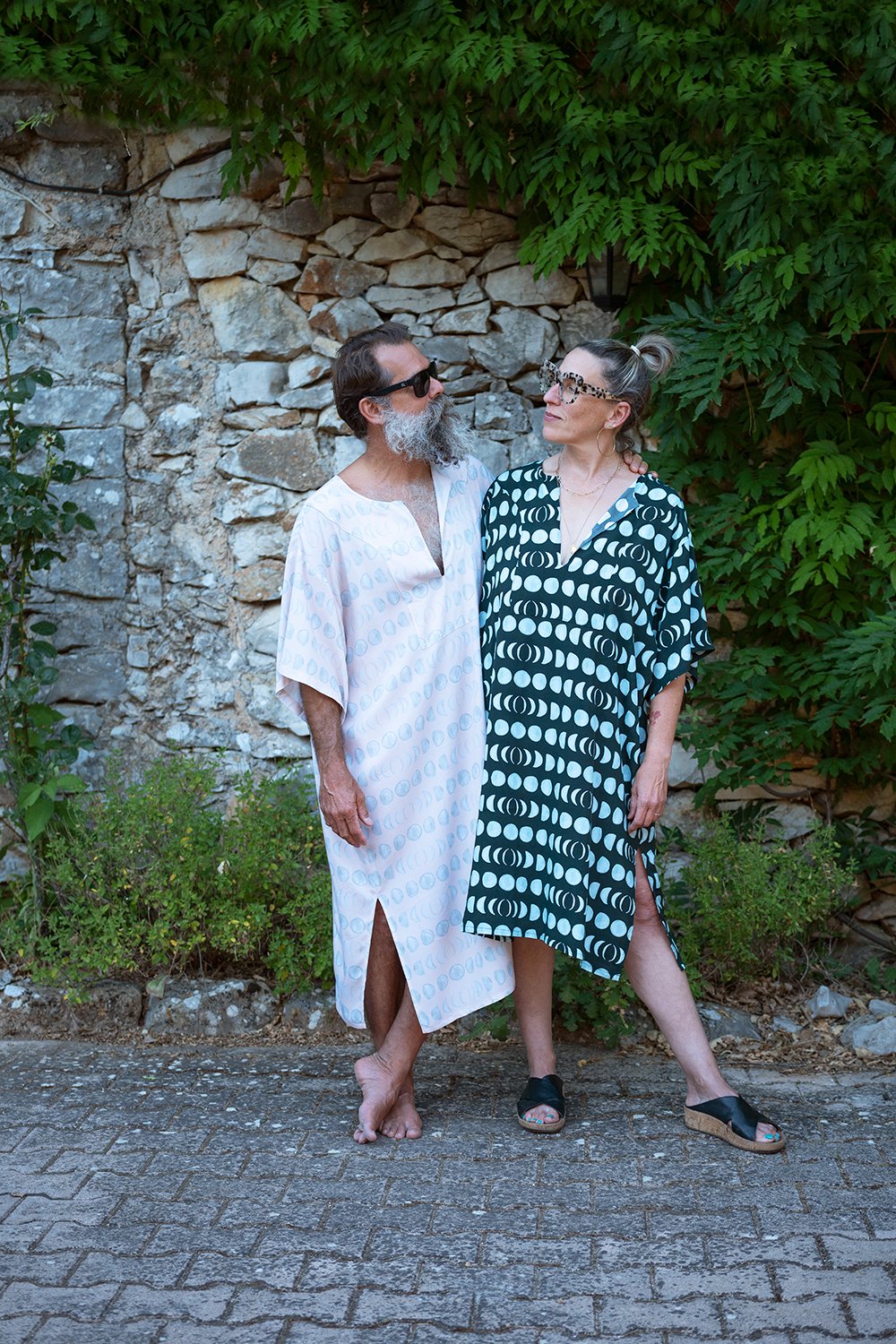 Man and Woman wearing the Unisex Piqué Lounge Tunic sewing pattern from Christine Haynes on The Fold Line. A tunic pattern made in silk, rayon, linen, awn or tencel fabrics, featuring an over sized fit, drop shoulders, wide elbow-length sleeves, side seam