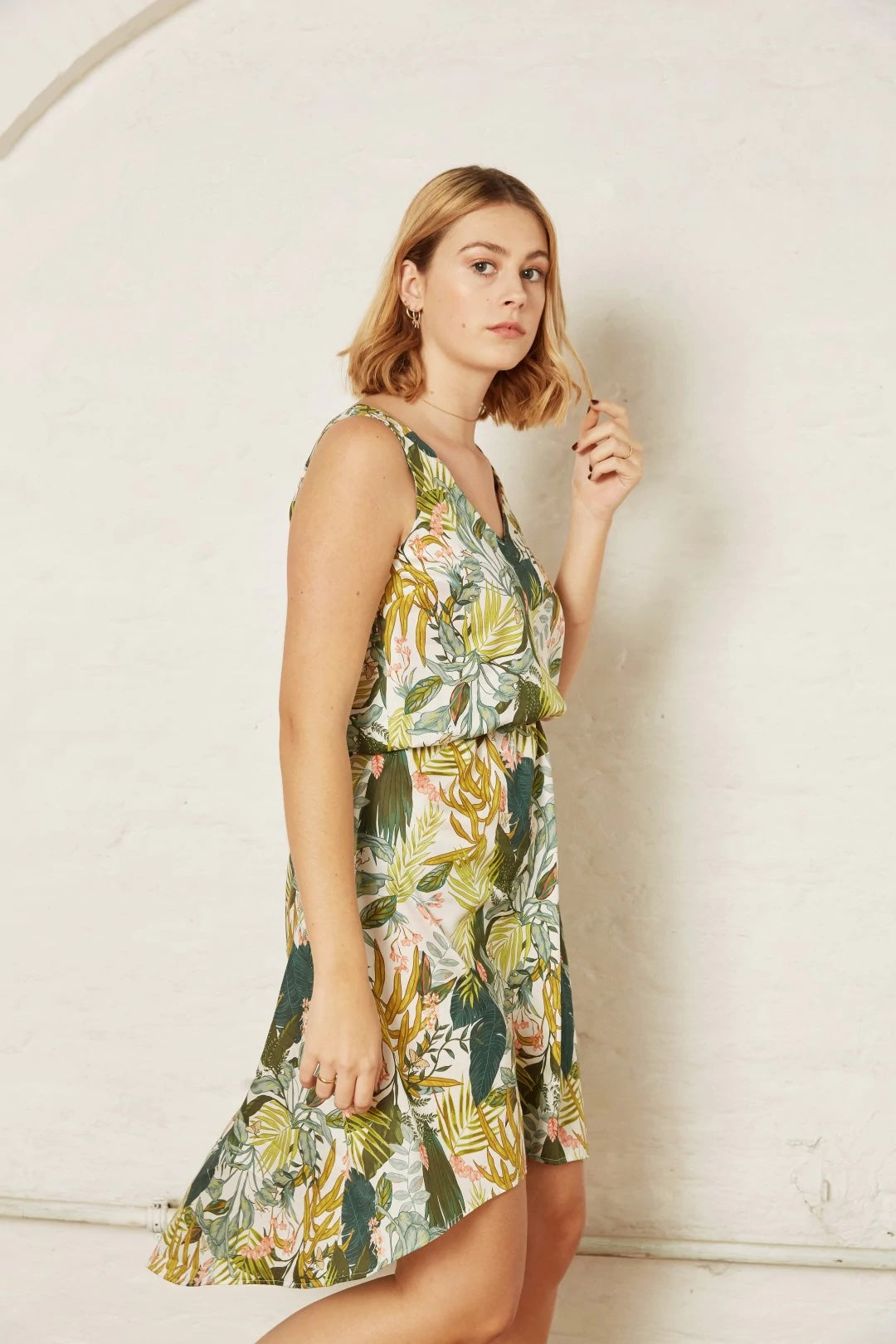 Woman wearing the Poppy Summer Dress sewing pattern from Atelier Jupe on The Fold Line. A dress pattern made in viscose or tencel fabrics, featuring an elasticated waistline, shoulder straps, V-neck, relaxed fit and high-low hem.